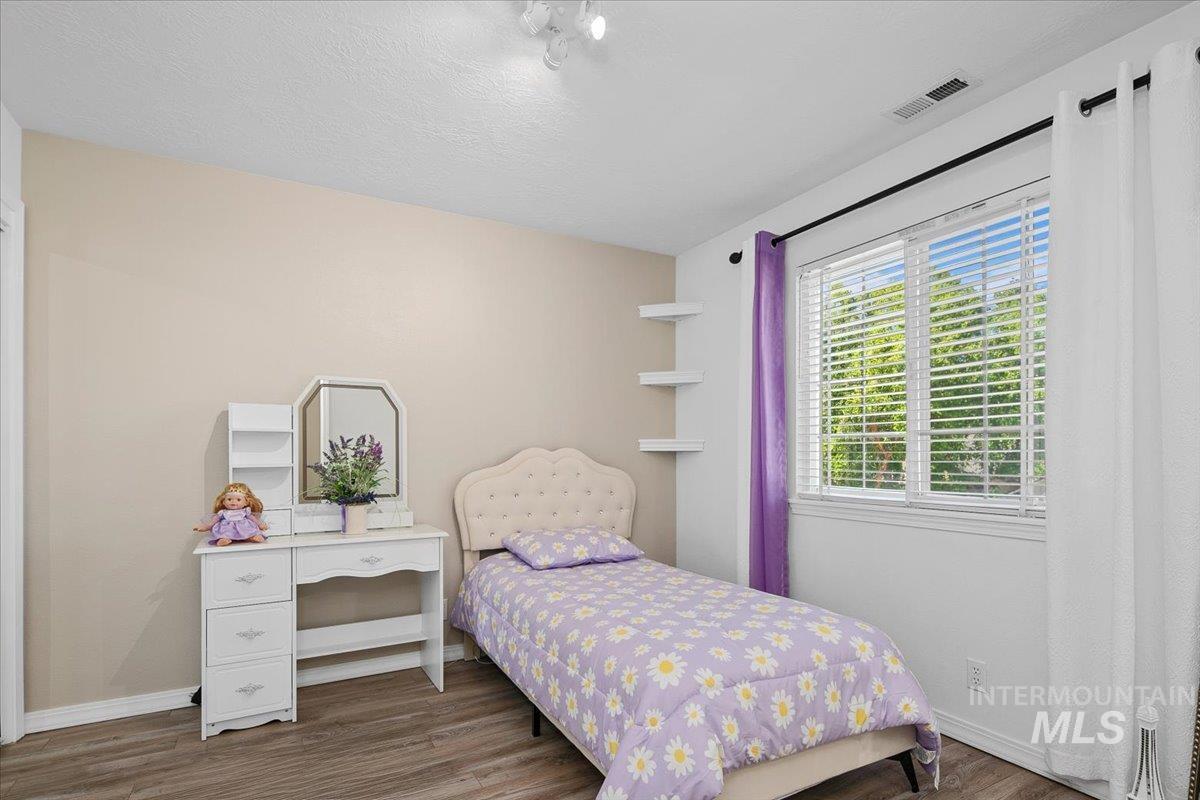 Bedroom with wood finished floors and a textured ceiling