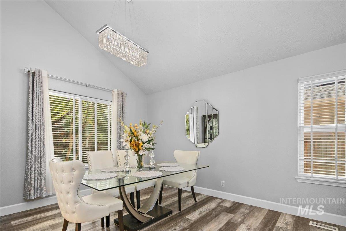 Dining space featuring wood finished floors and high vaulted ceiling