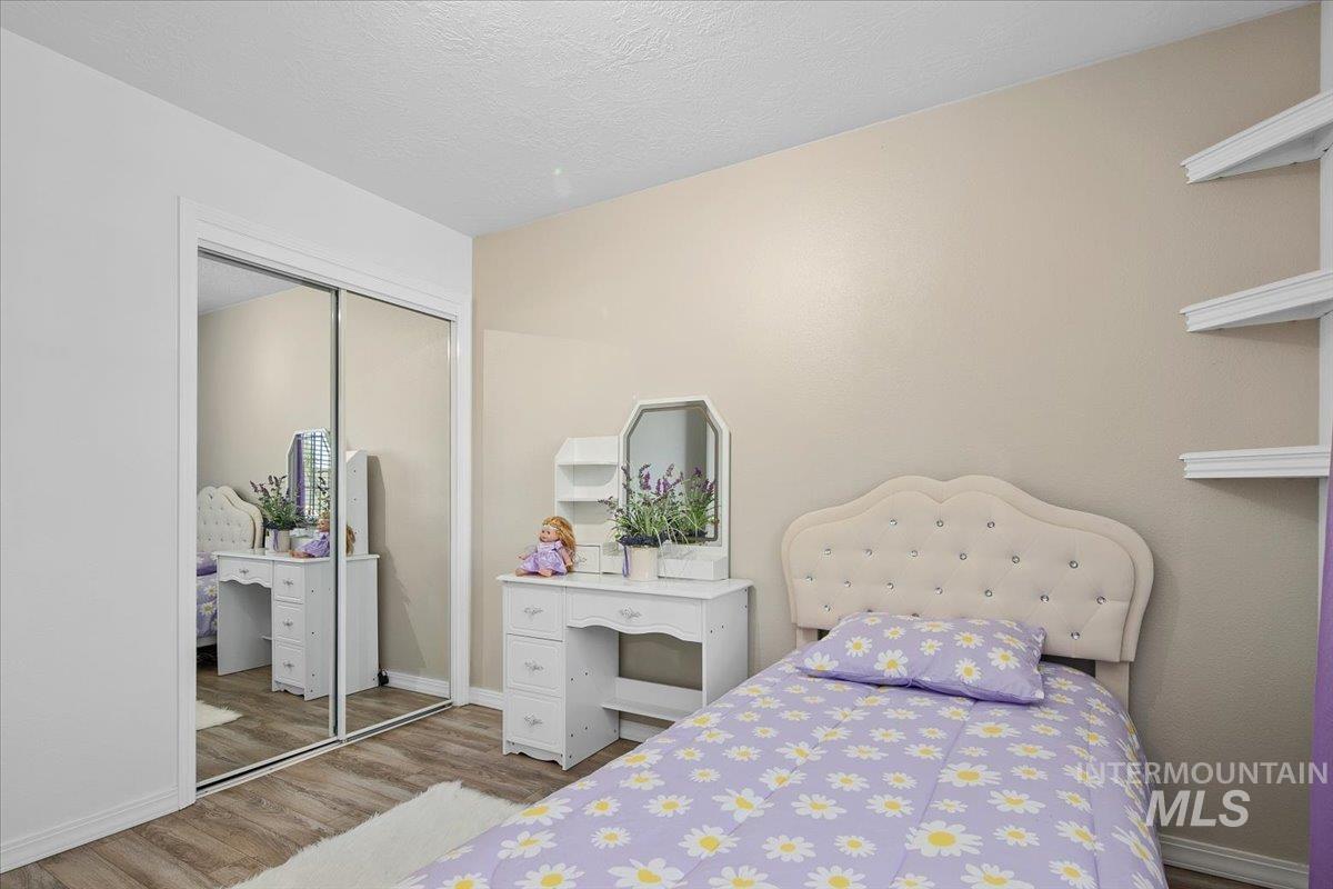 Bedroom featuring wood finished floors, a closet, and a textured ceiling