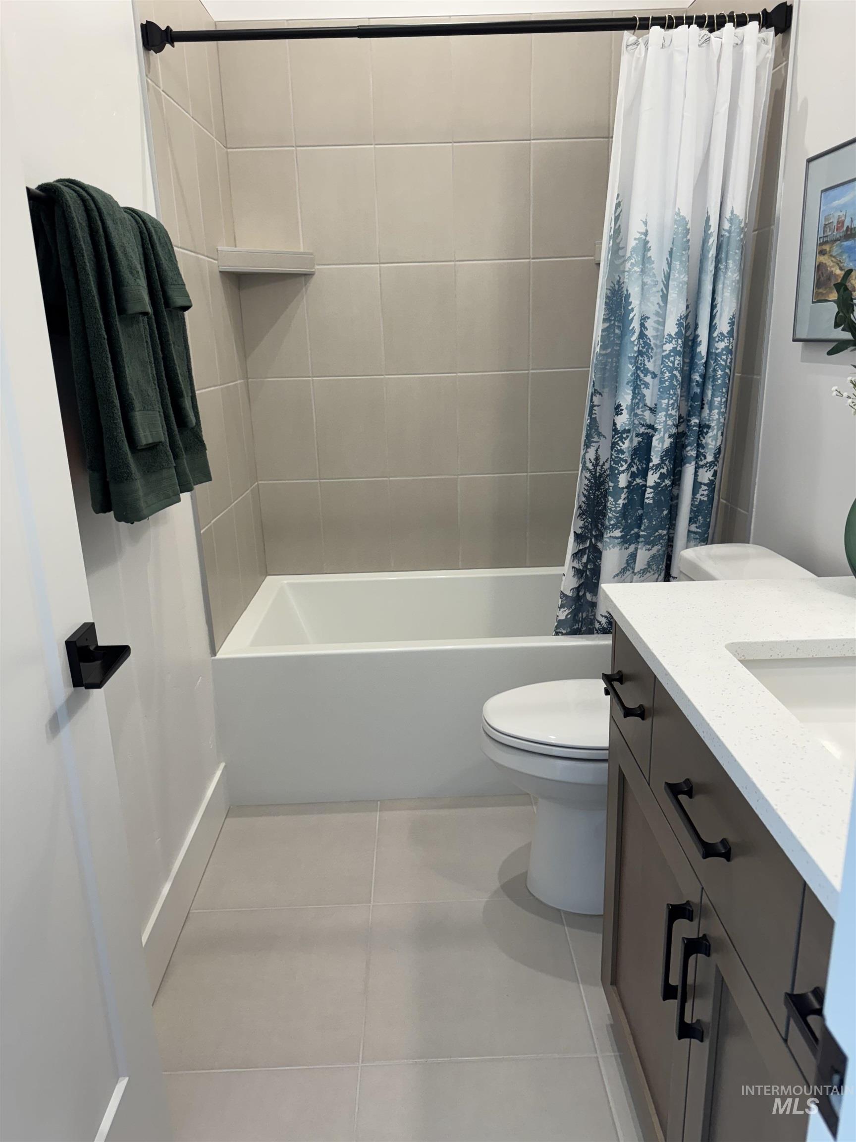 Full bath featuring shower / bath combination with curtain, tile patterned floors, and vanity