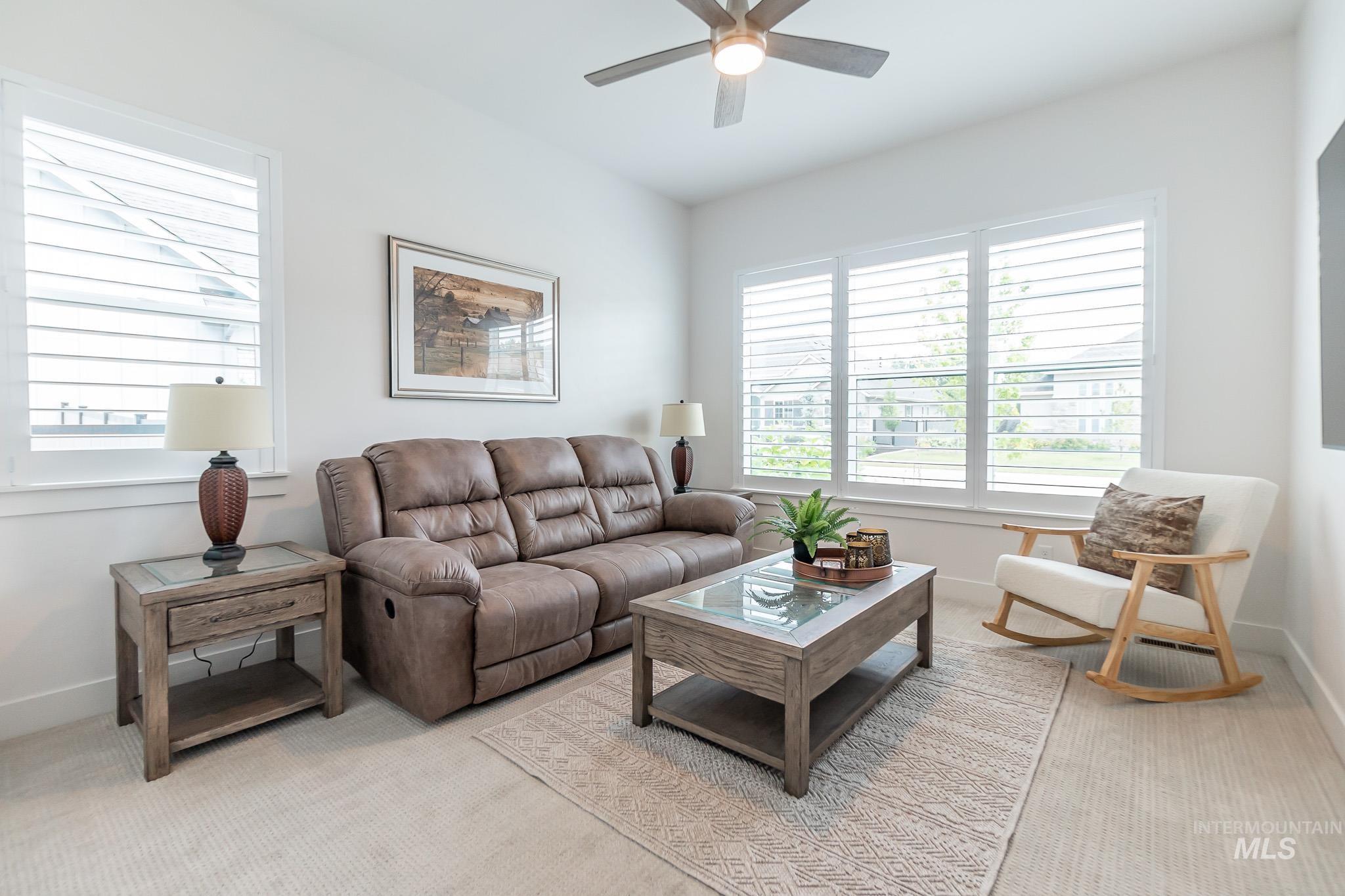 Living room featuring a ceiling fan and light carpet