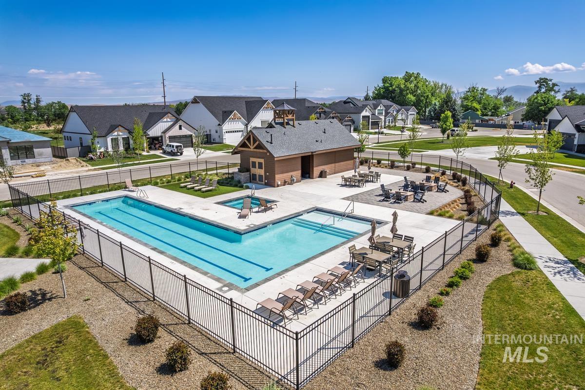 Community pool with a residential view, a hot tub, and a patio