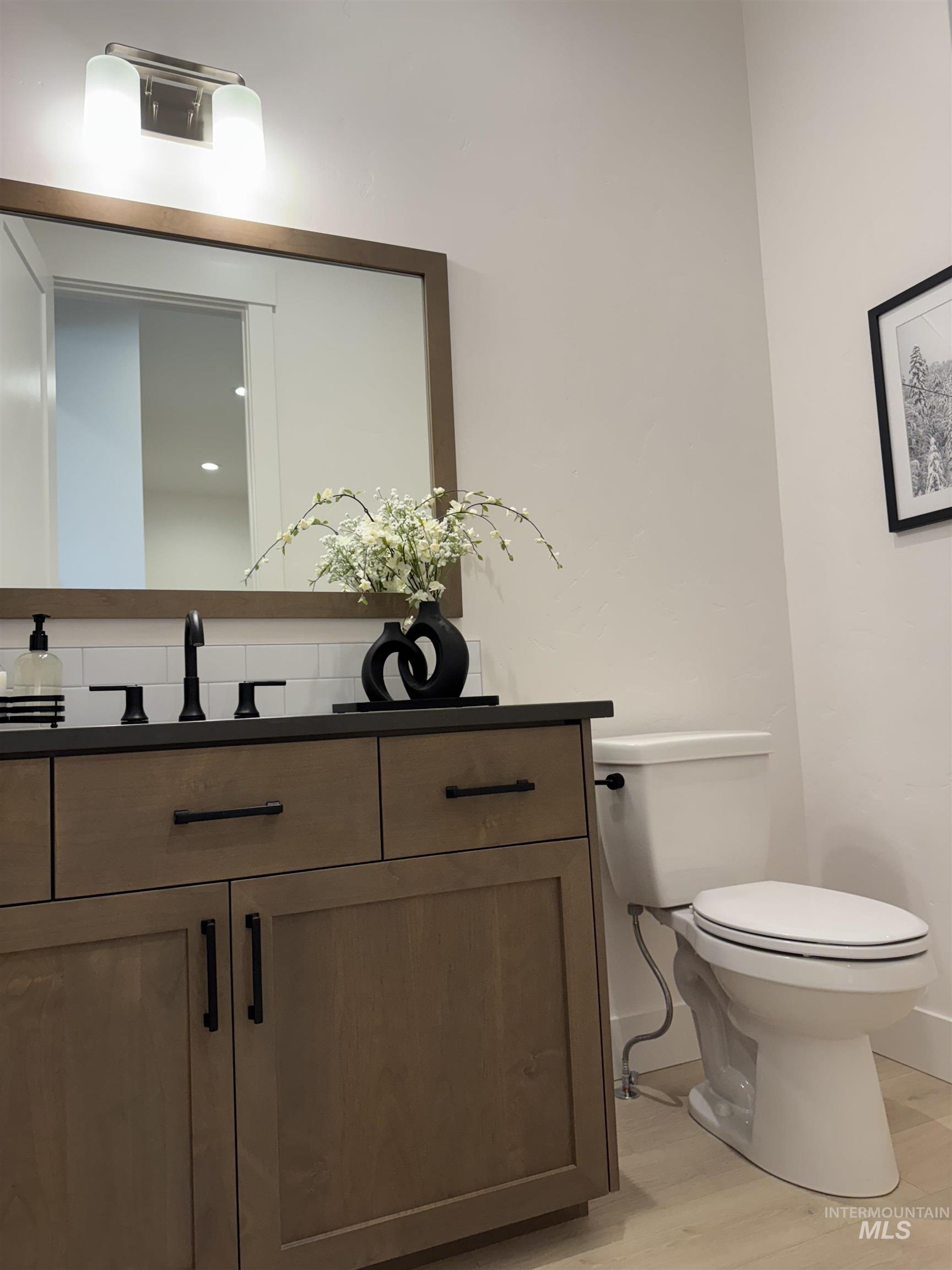 Half bathroom with vanity and wood finished floors