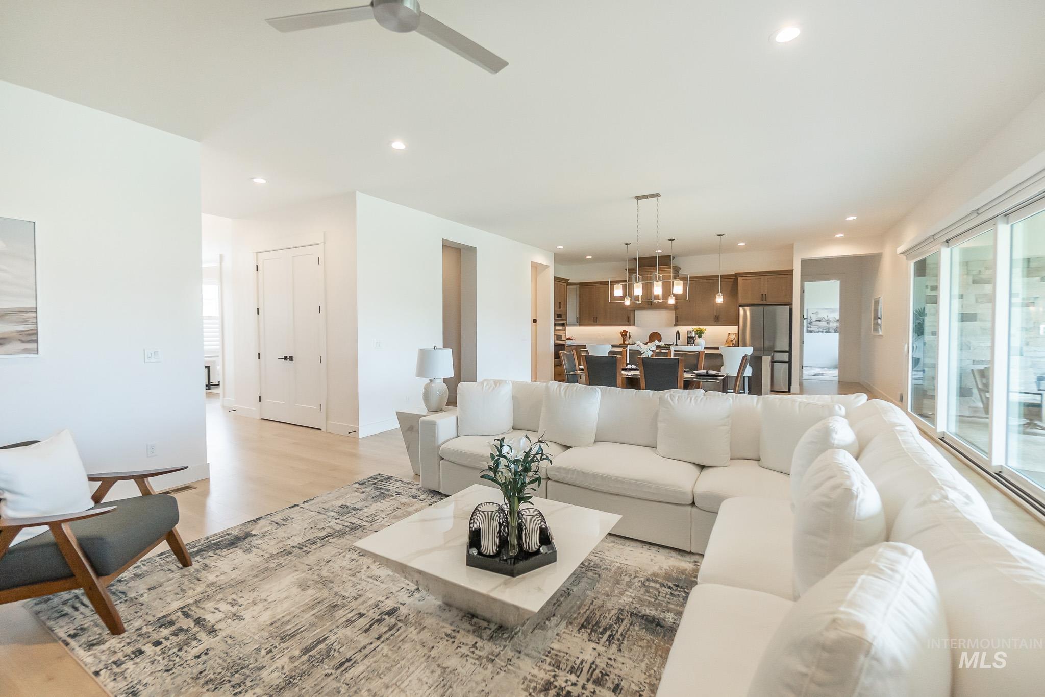 Living room with light wood-type flooring, ceiling fan, and recessed lighting