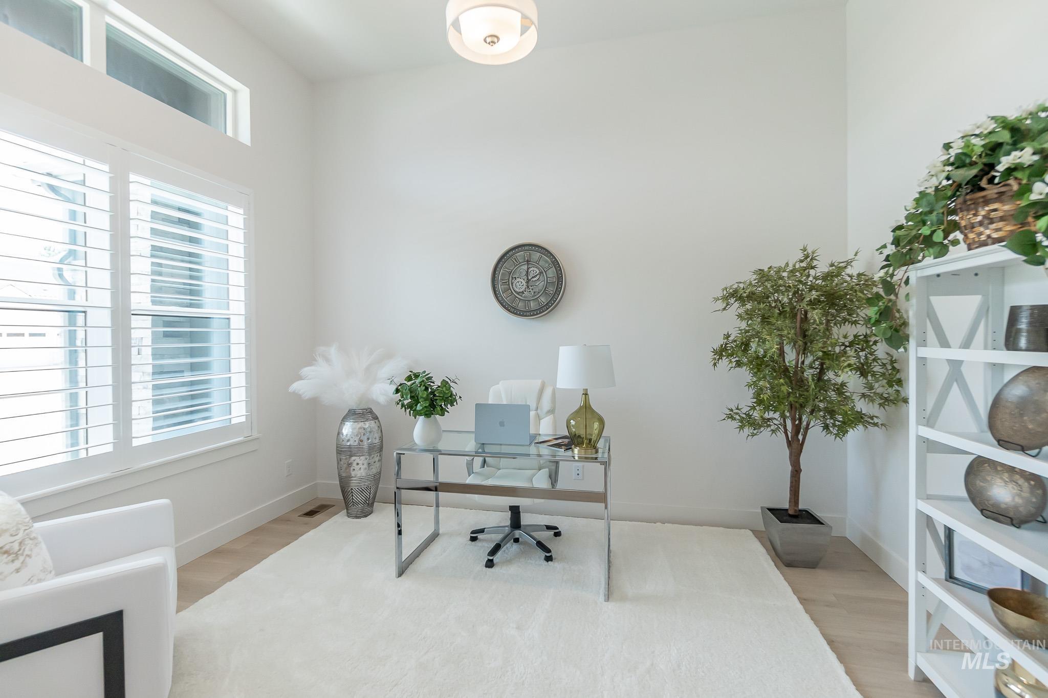 Home office with healthy amount of natural light and wood finished floors