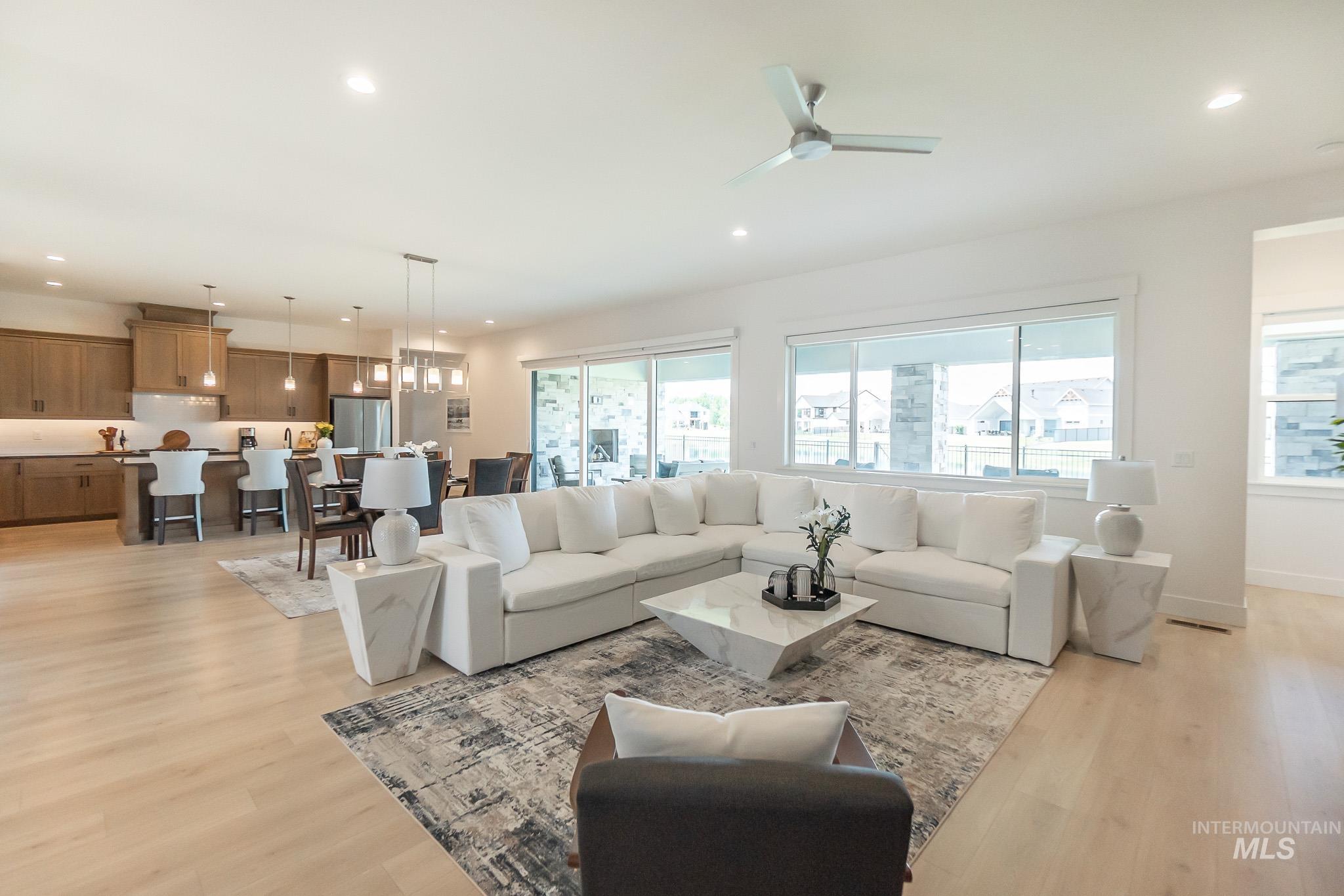 Living room featuring light wood-style floors, recessed lighting, and ceiling fan