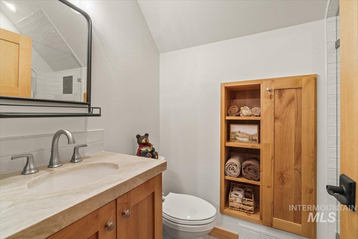 Half bath featuring vanity and lofted ceiling
