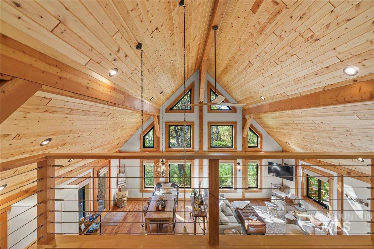 Unfurnished living room featuring a wood ceiling with exposed beams, hardwood / wood-style floors, and high vaulted ceiling