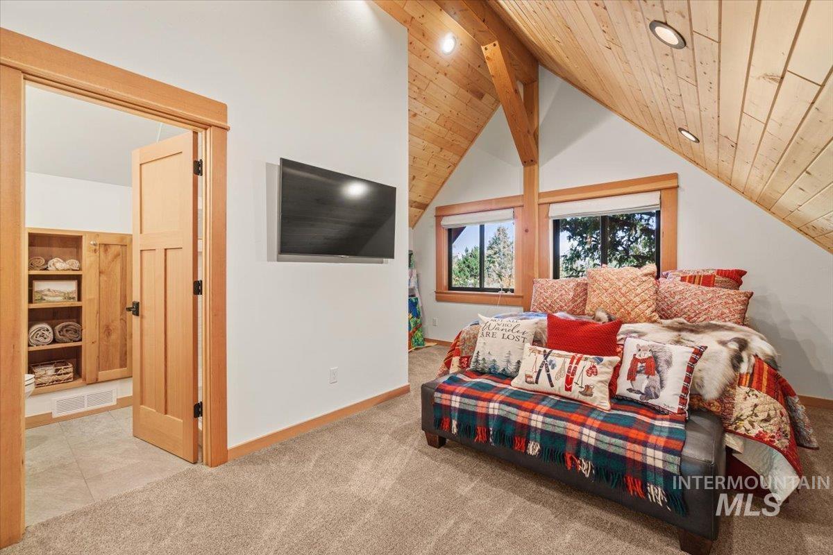 Carpeted bedroom featuring wooden ceiling, tile patterned floors, and recessed lighting