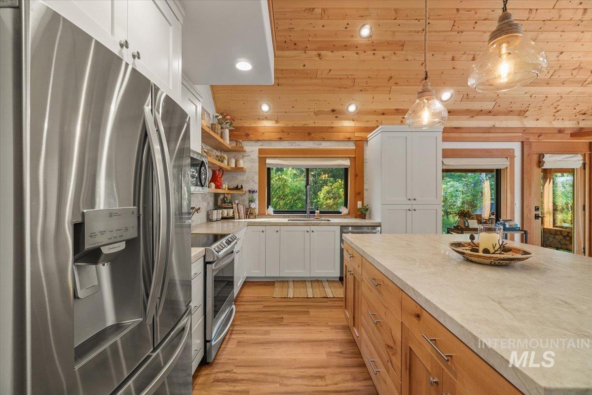 Kitchen with recessed lighting, appliances with stainless steel finishes, open shelves, white cabinetry, and pendant lighting