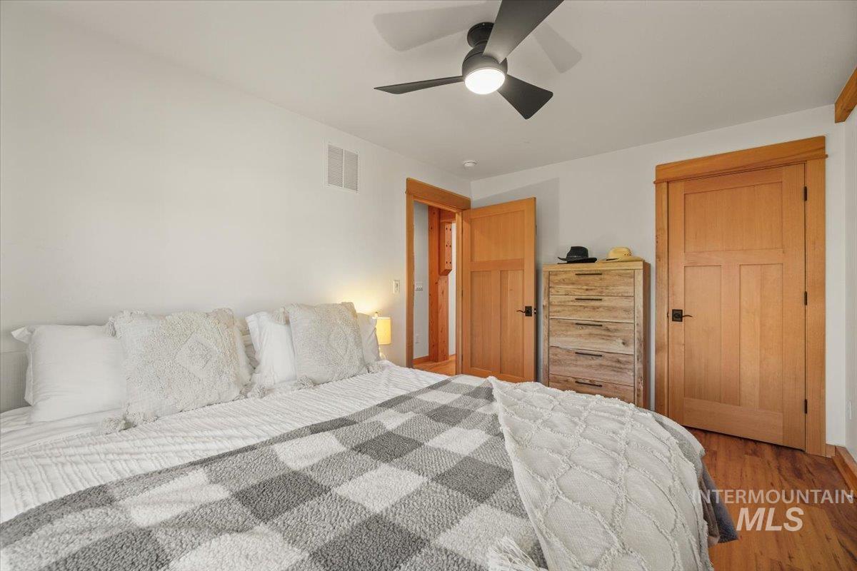 Bedroom with wood finished floors, ceiling fan, and a closet