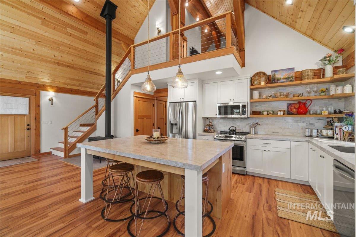 Kitchen featuring open shelves, white cabinets, high vaulted ceiling, light wood-type flooring, and wood ceiling