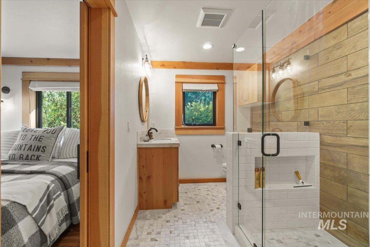 Full bath featuring vanity, a shower stall, ensuite bath, and recessed lighting
