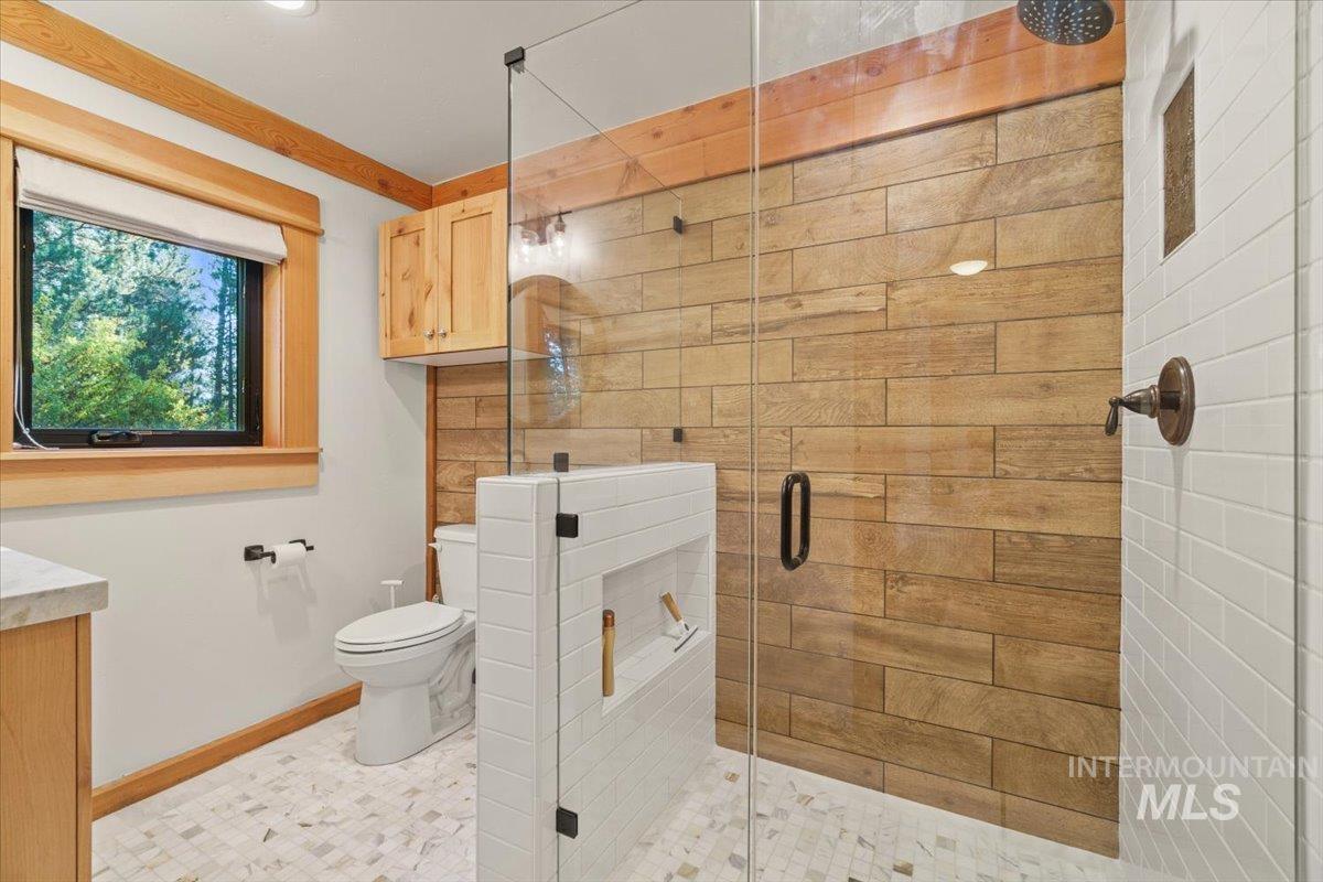 Bathroom featuring a shower stall, vanity, and tile patterned floors