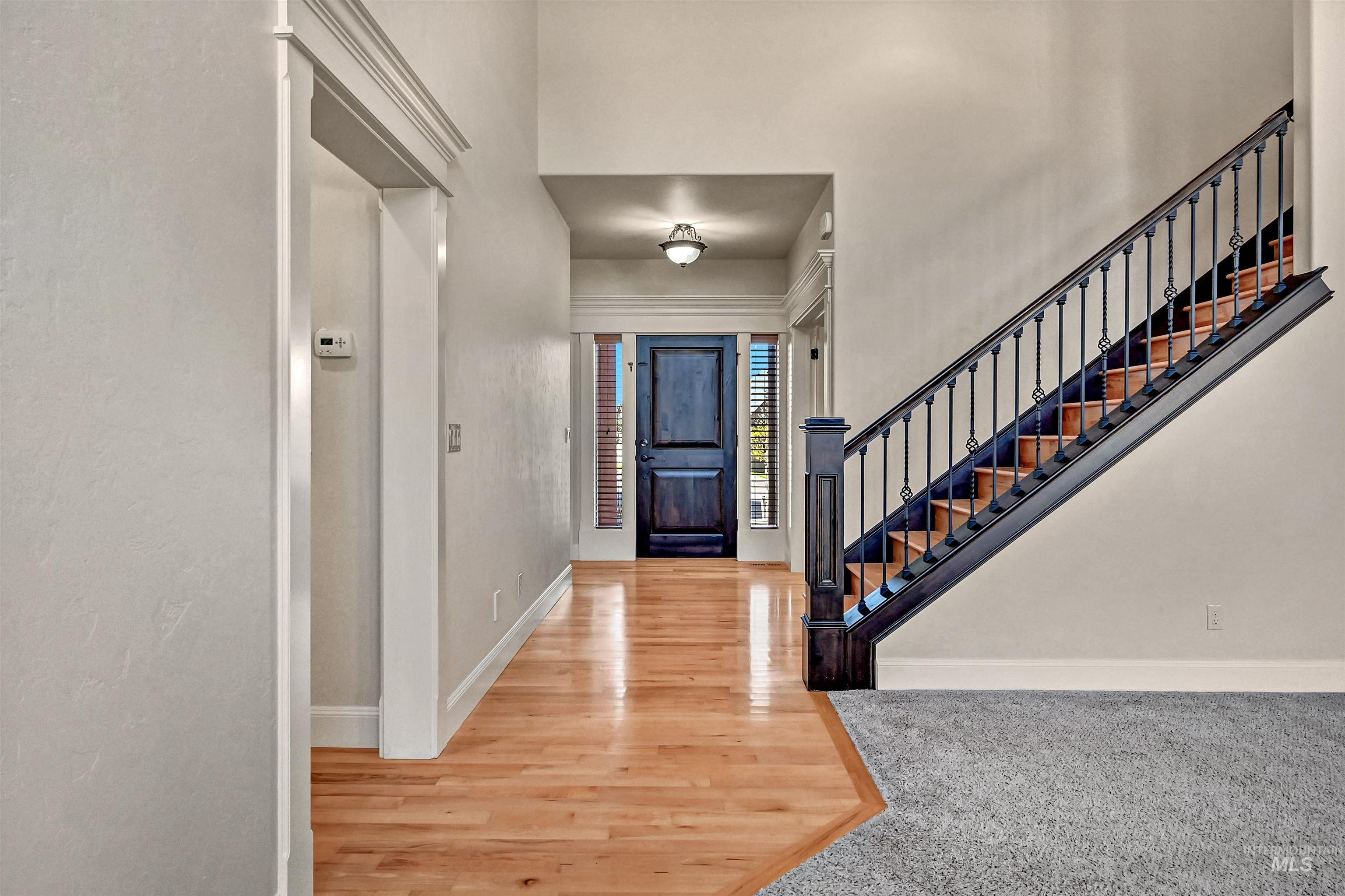 Foyer featuring light wood-style flooring and stairway