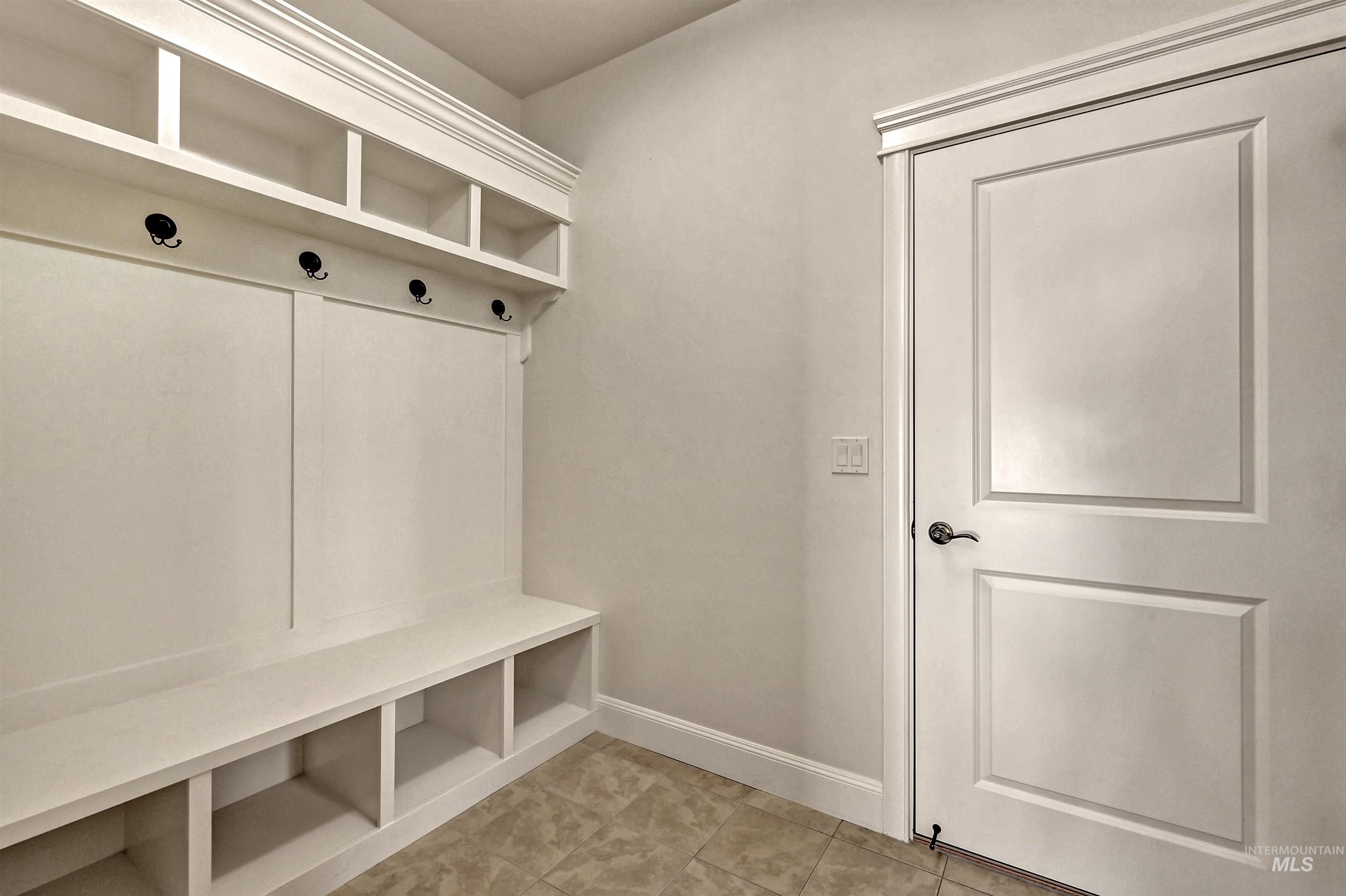 Mudroom featuring baseboards and light tile patterned floors
