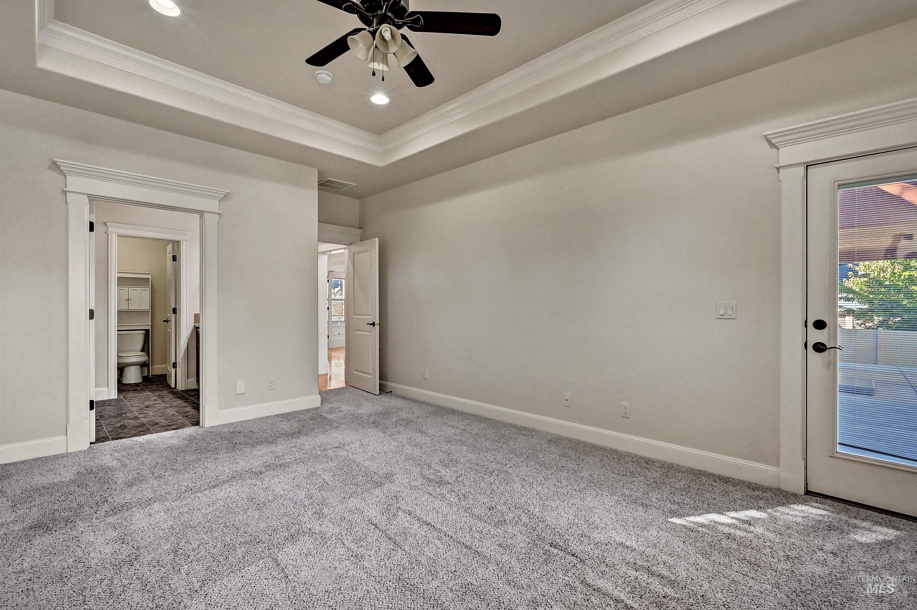 Unfurnished bedroom with ornamental molding, a tray ceiling, recessed lighting, carpet floors, and access to outside