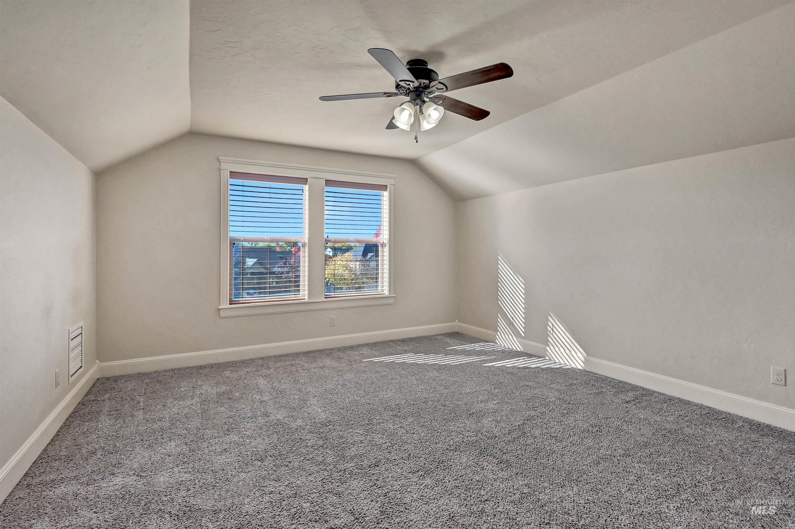 Bonus room with vaulted ceiling, carpet flooring, and ceiling fan