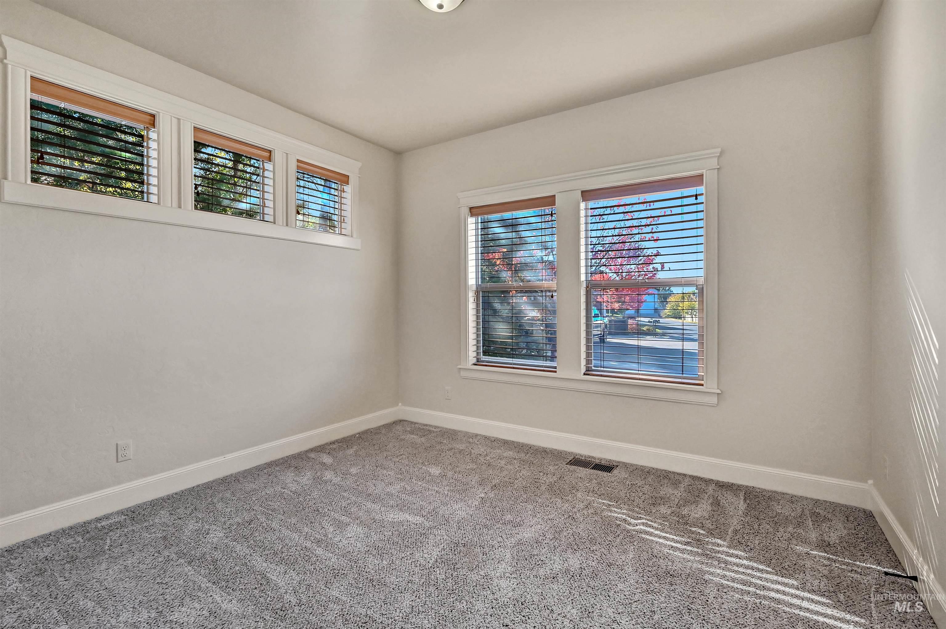 Empty room featuring carpet flooring and baseboards