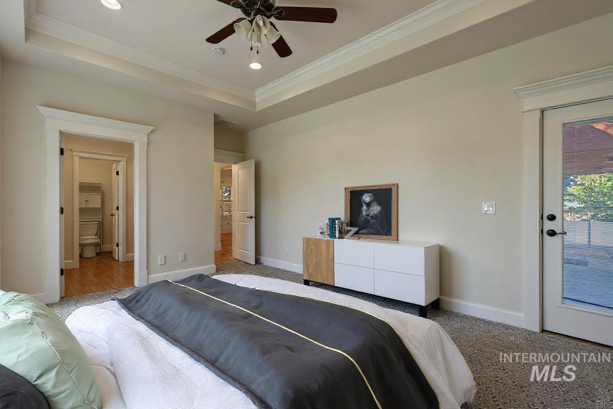 Bedroom with a tray ceiling, crown molding, access to outside, recessed lighting, and a ceiling fan