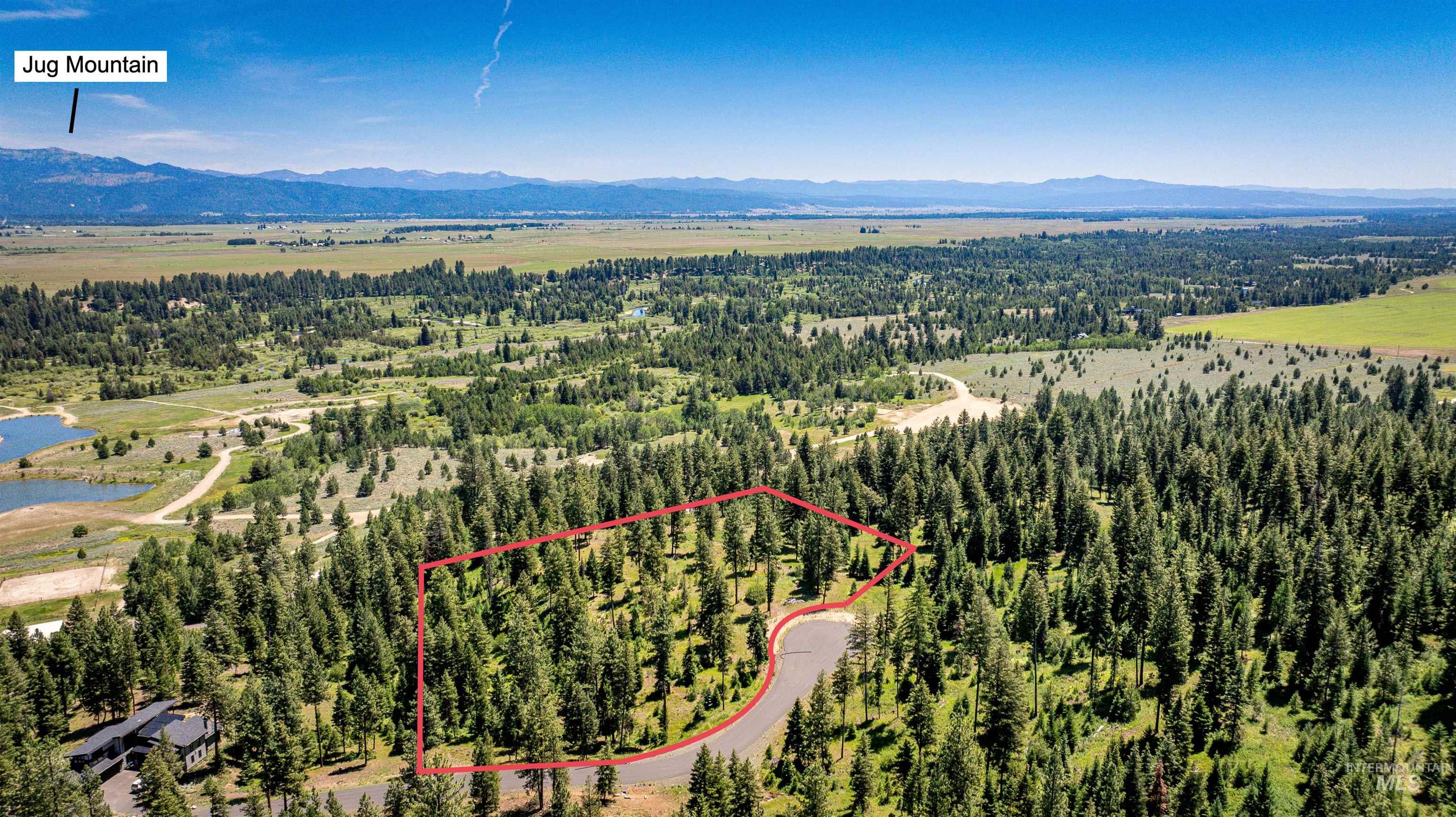 Aerial overview of property's location with property boundaries highlighted and a water and mountain view