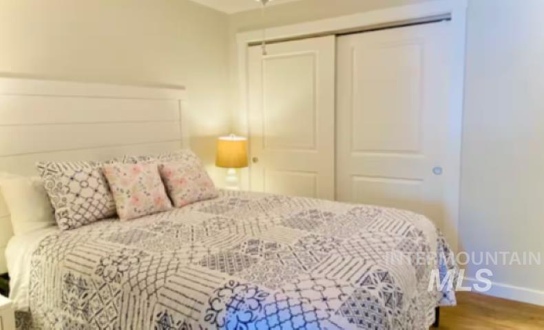Bedroom with wood finished floors and a closet