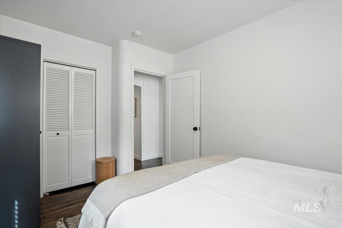 Bedroom featuring dark wood-style floors and a closet