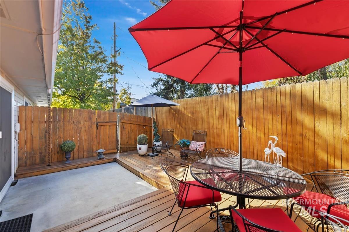 Wooden terrace featuring a fenced backyard and outdoor dining area