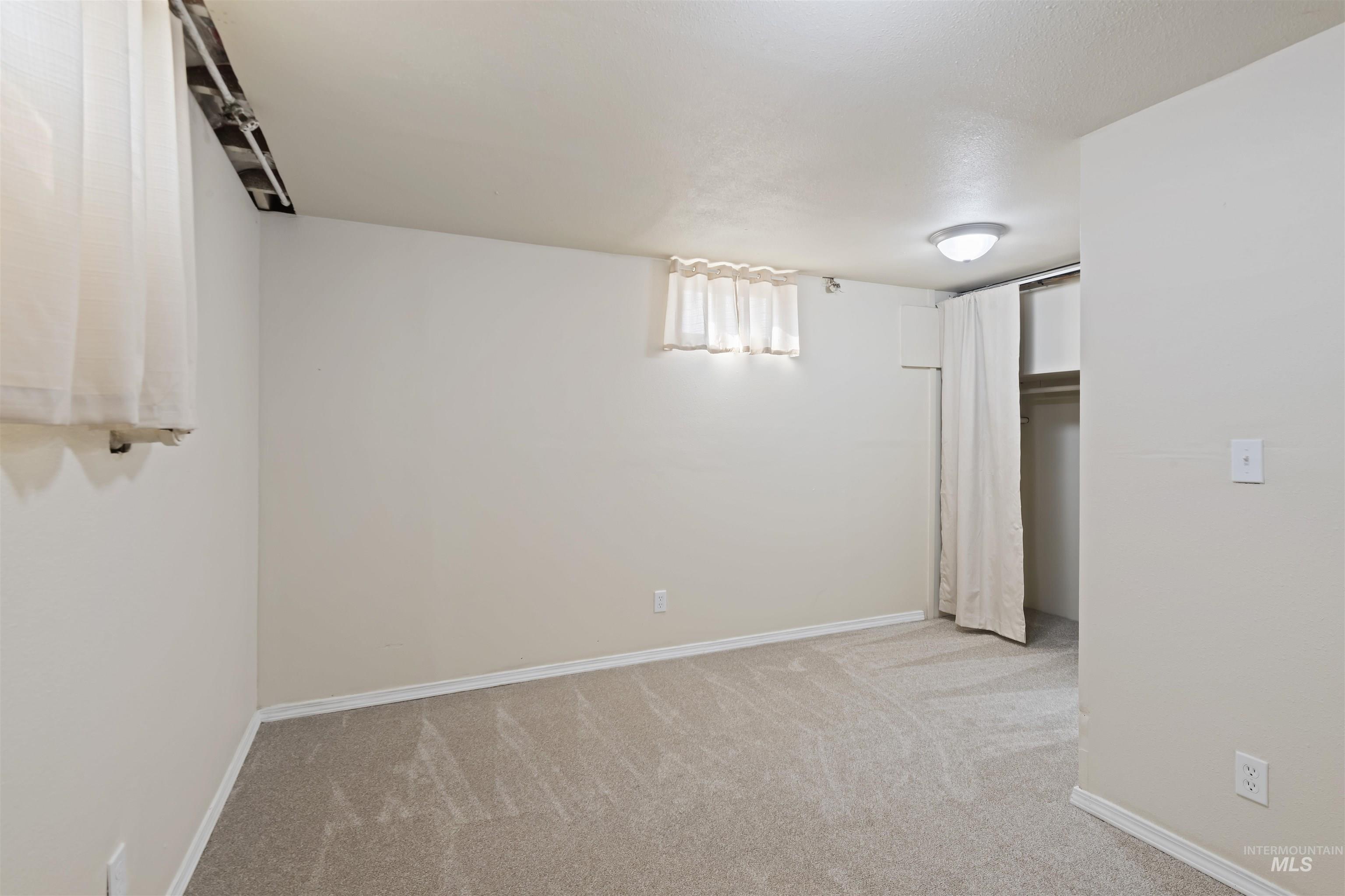 Below grade area with light colored carpet and baseboards