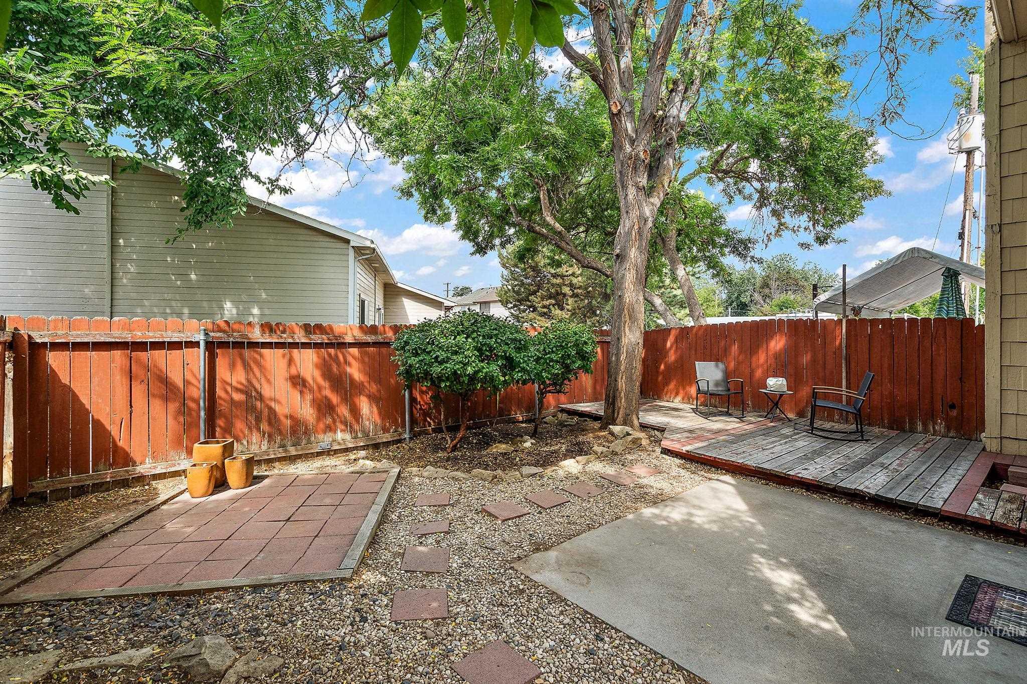 Fenced backyard featuring a deck and a patio