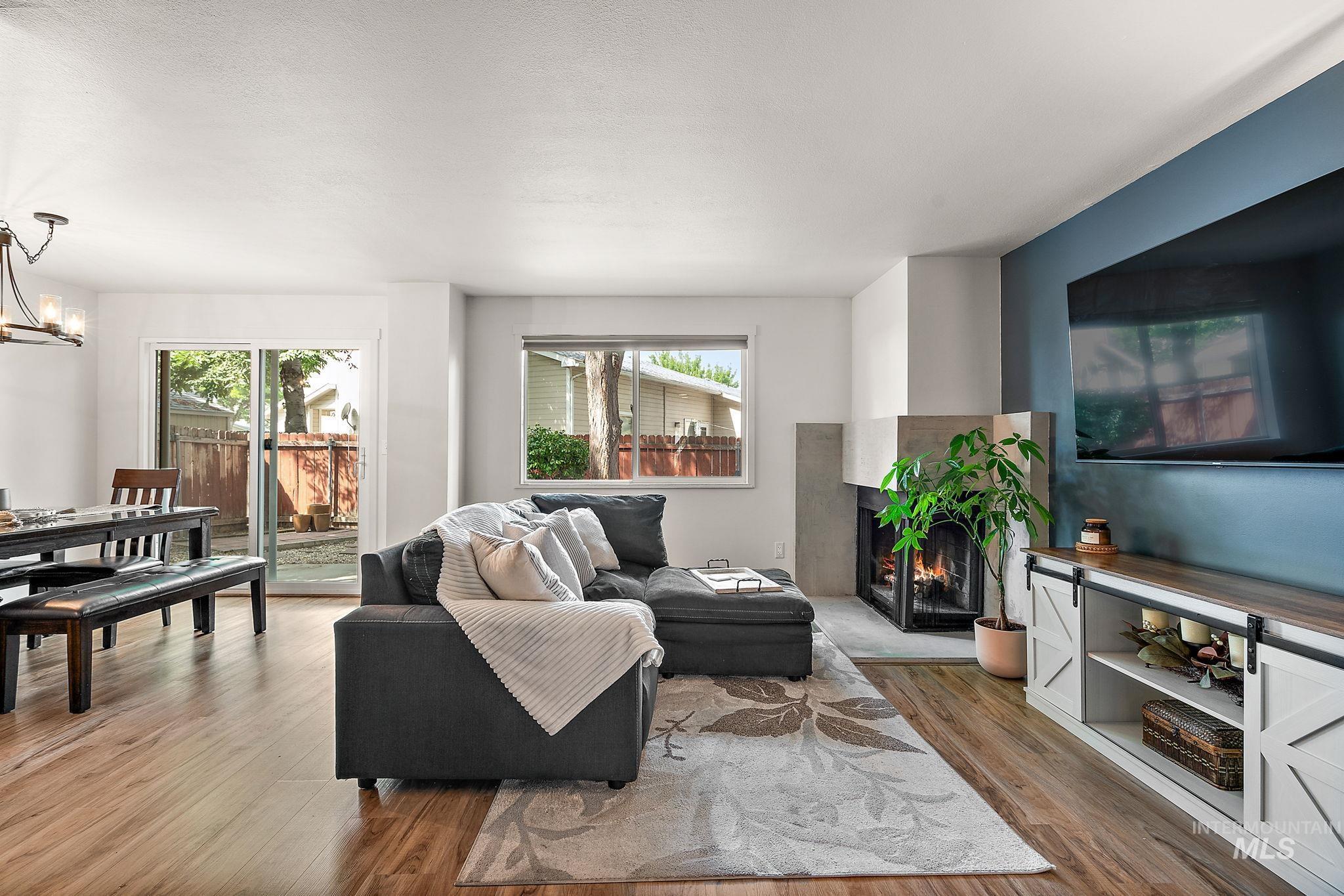 Living room featuring a lit fireplace, light wood-style floors, and a chandelier