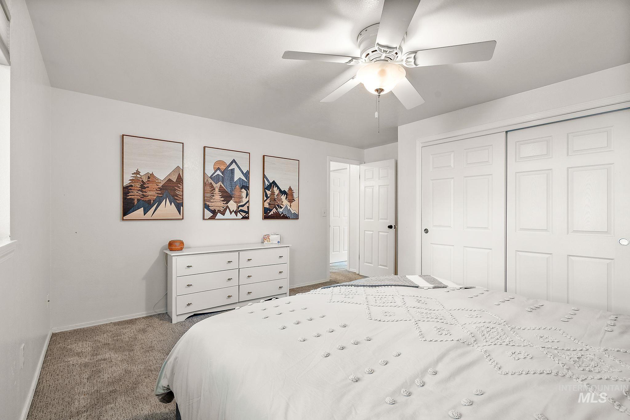 Bedroom featuring light colored carpet, a closet, and ceiling fan