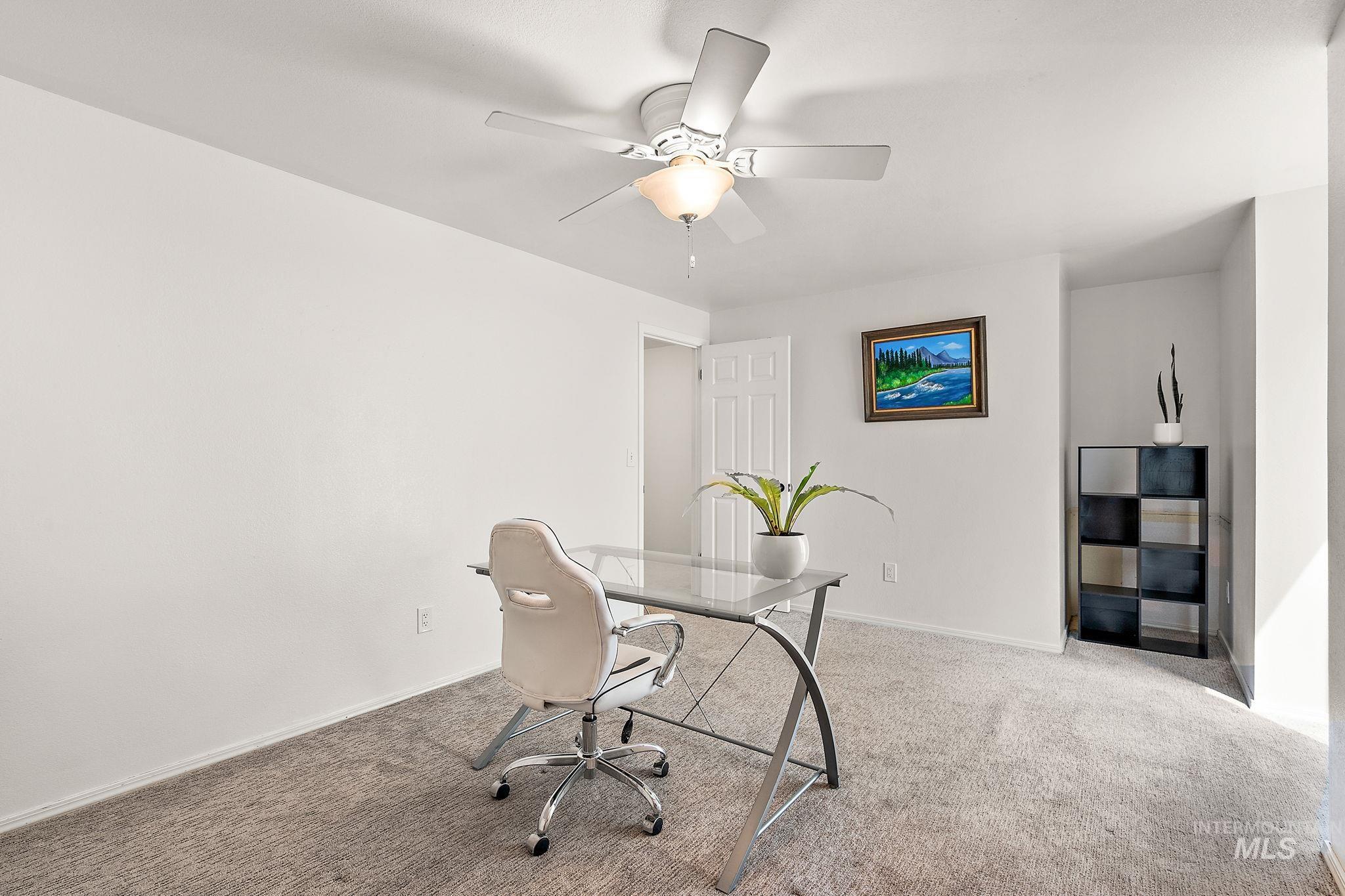 Office area with carpet floors and a ceiling fan