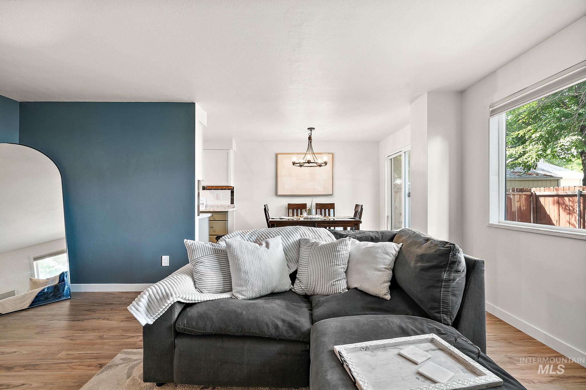 Living area with wood finished floors, a chandelier, and arched walkways