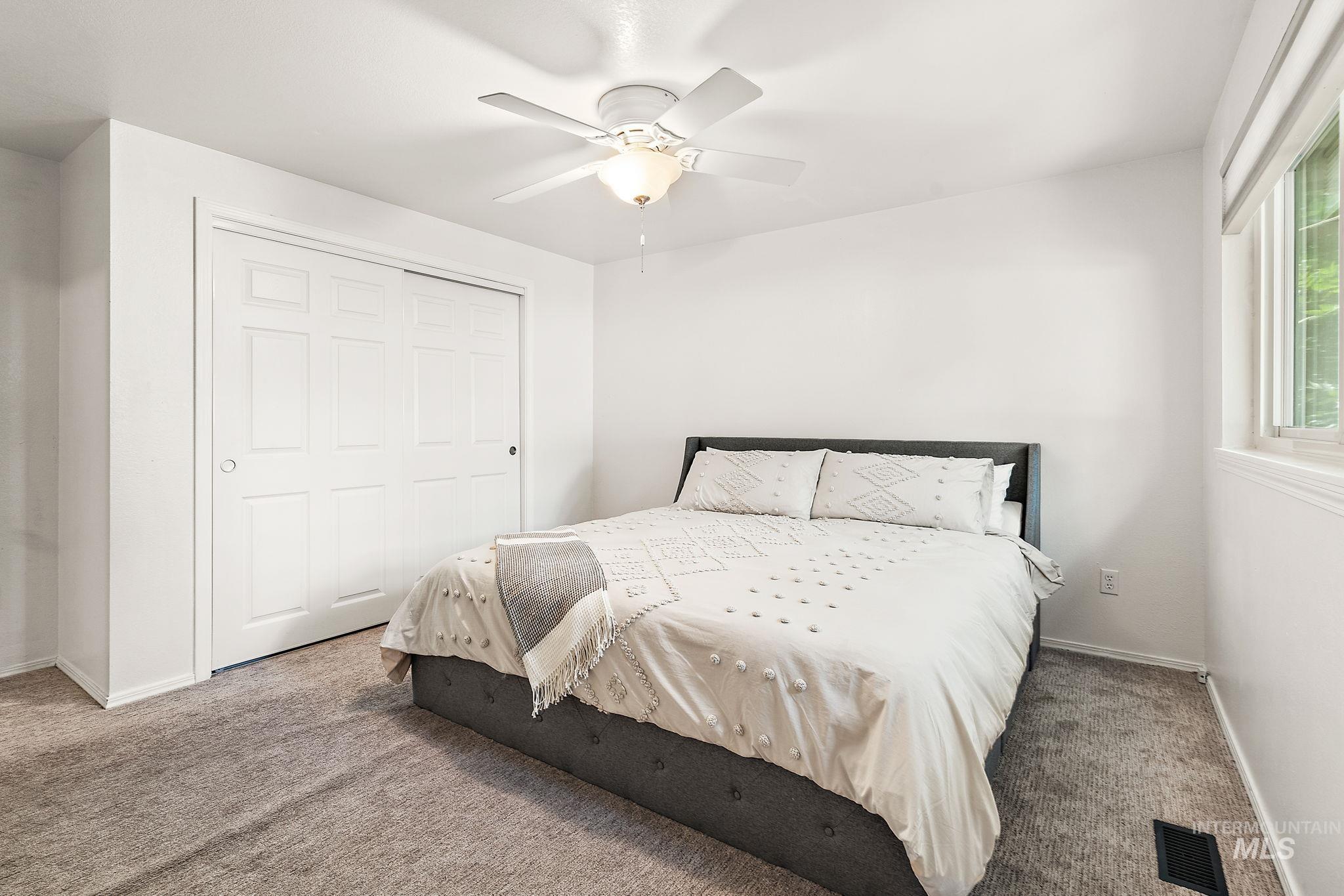 Carpeted bedroom featuring a closet and ceiling fan