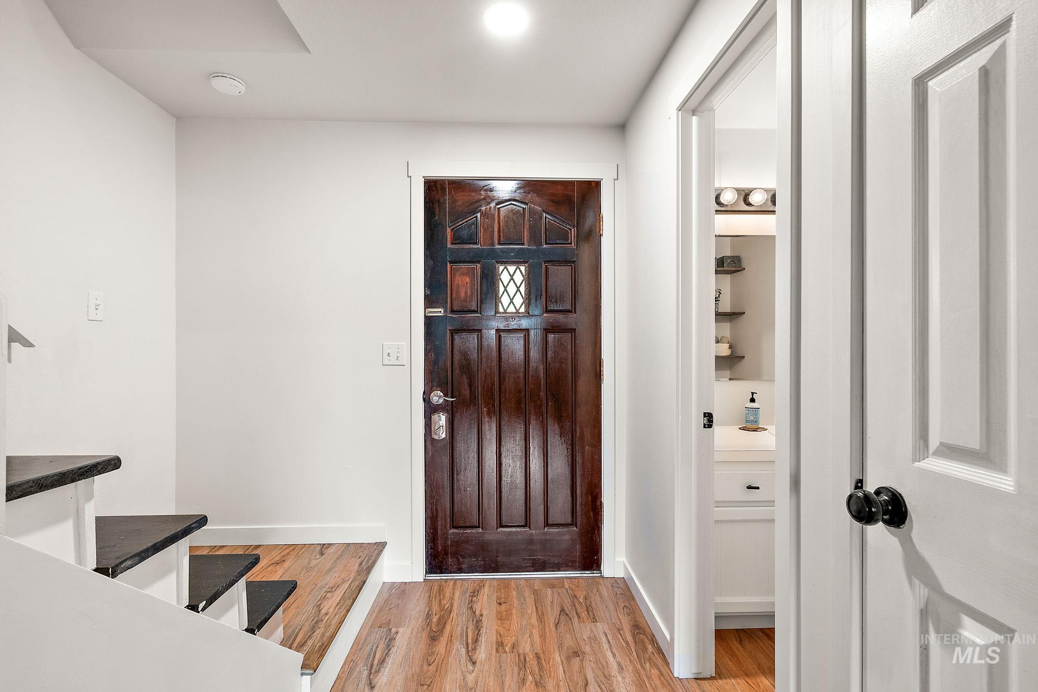 Foyer entrance with light wood-style floors, recessed lighting, and stairway