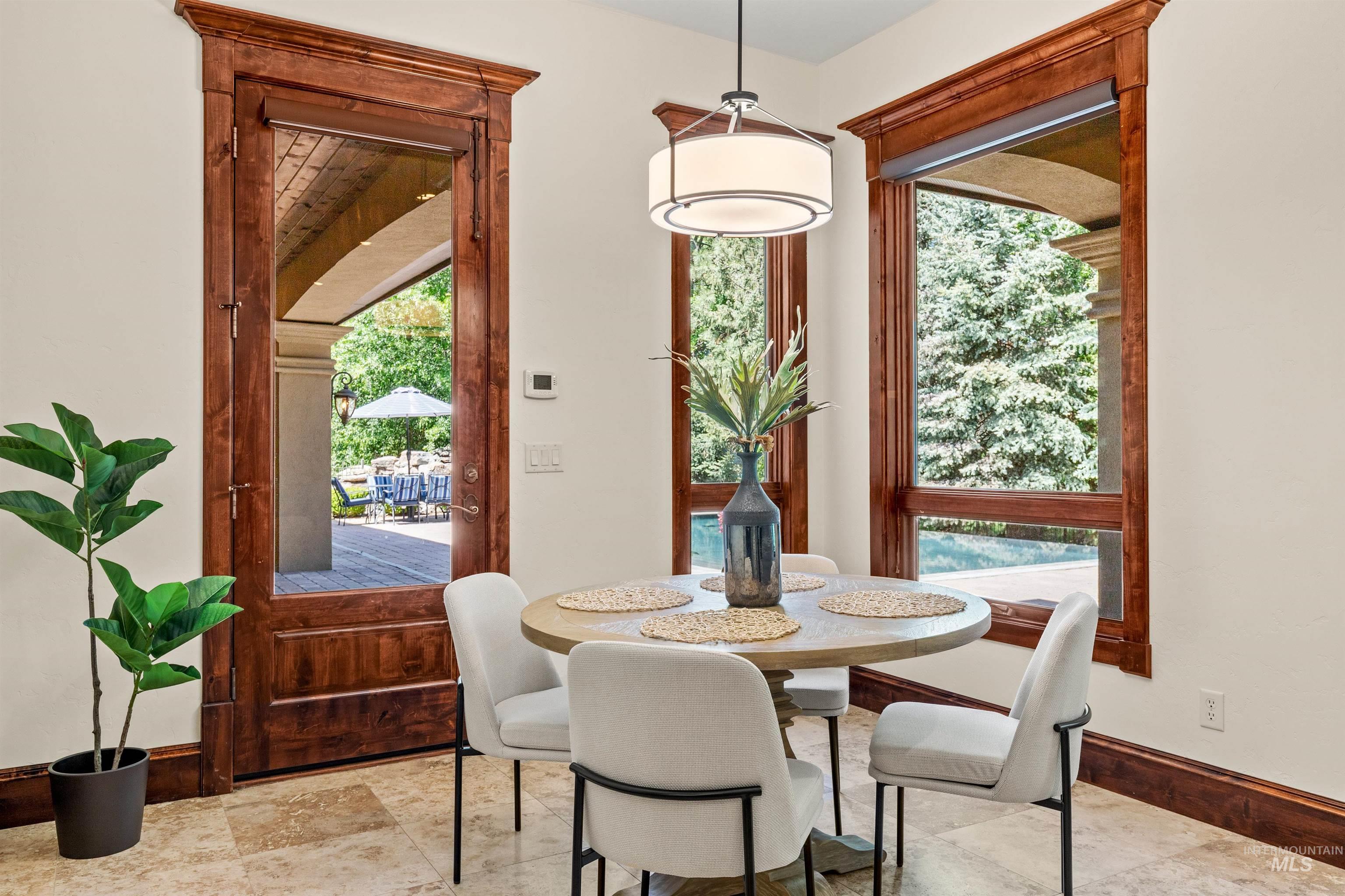 Travertine tile flooring with rich wood-finish trim and custom door leading to an outdoor patio