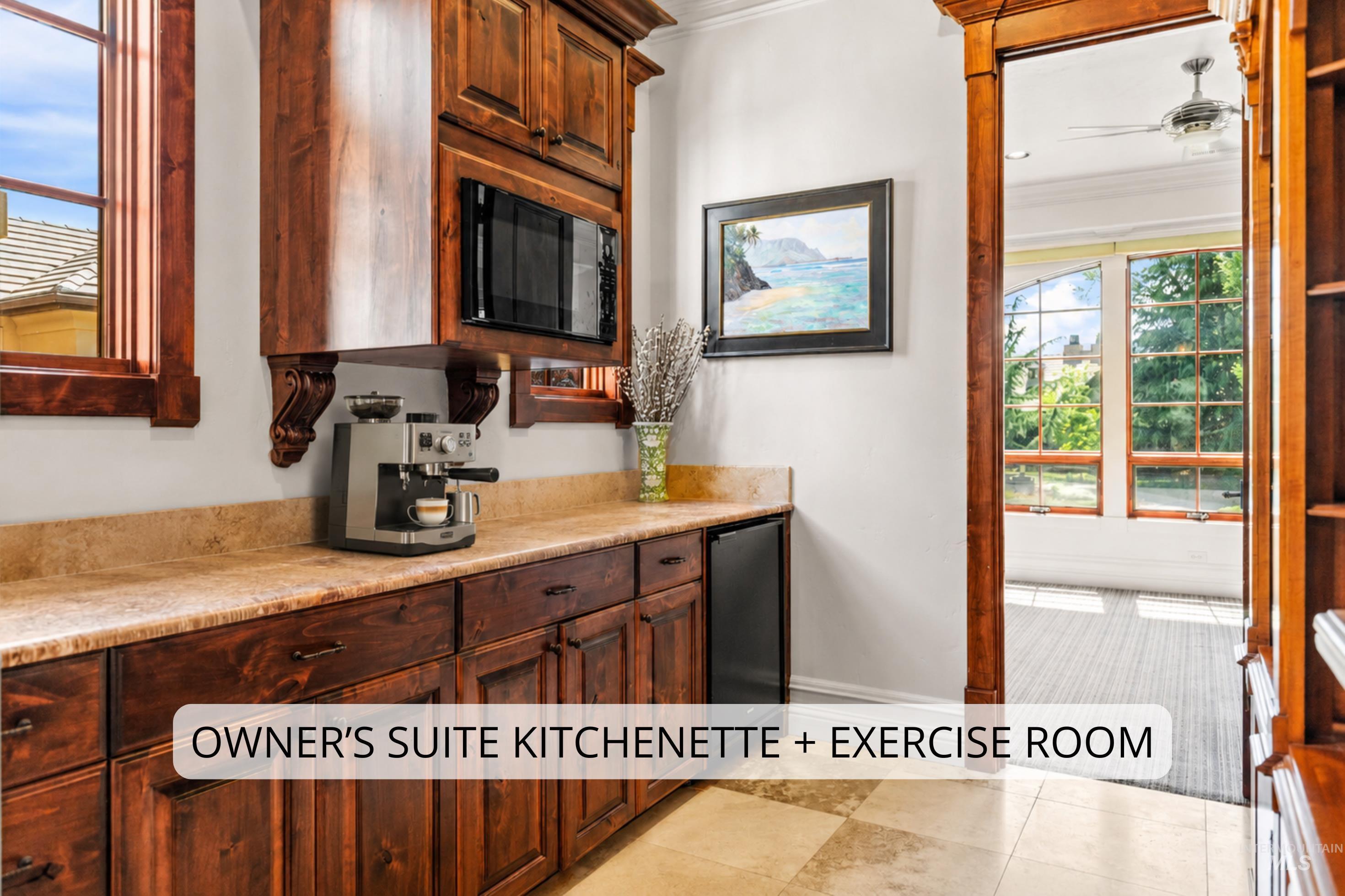 Kitchenette featuring custom wood cabinetry, a built-in microwave, and stone countertops