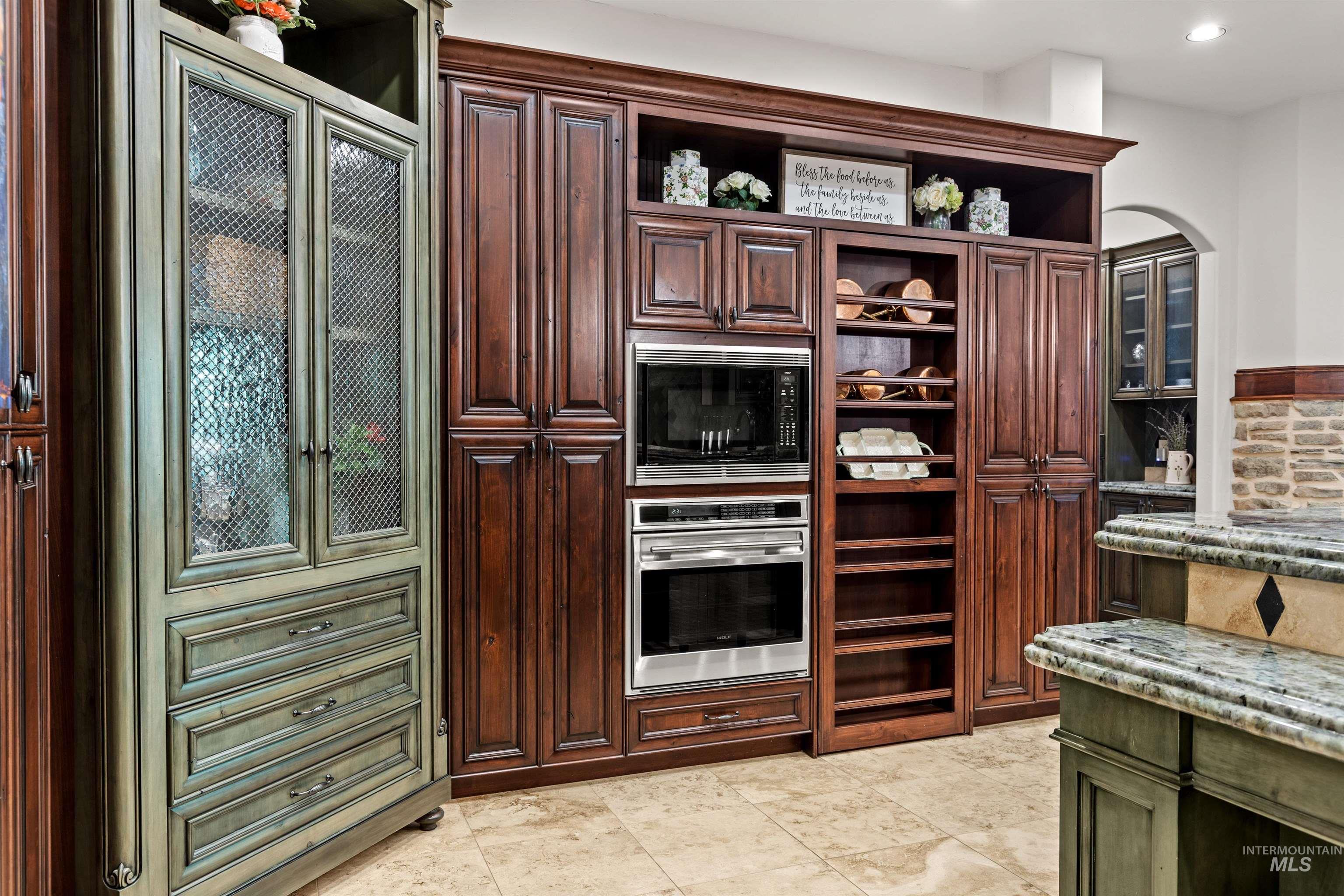 Custom cabinetry featuring rich wood-finish tones, integrated double ovens, and a dedicated spice rack