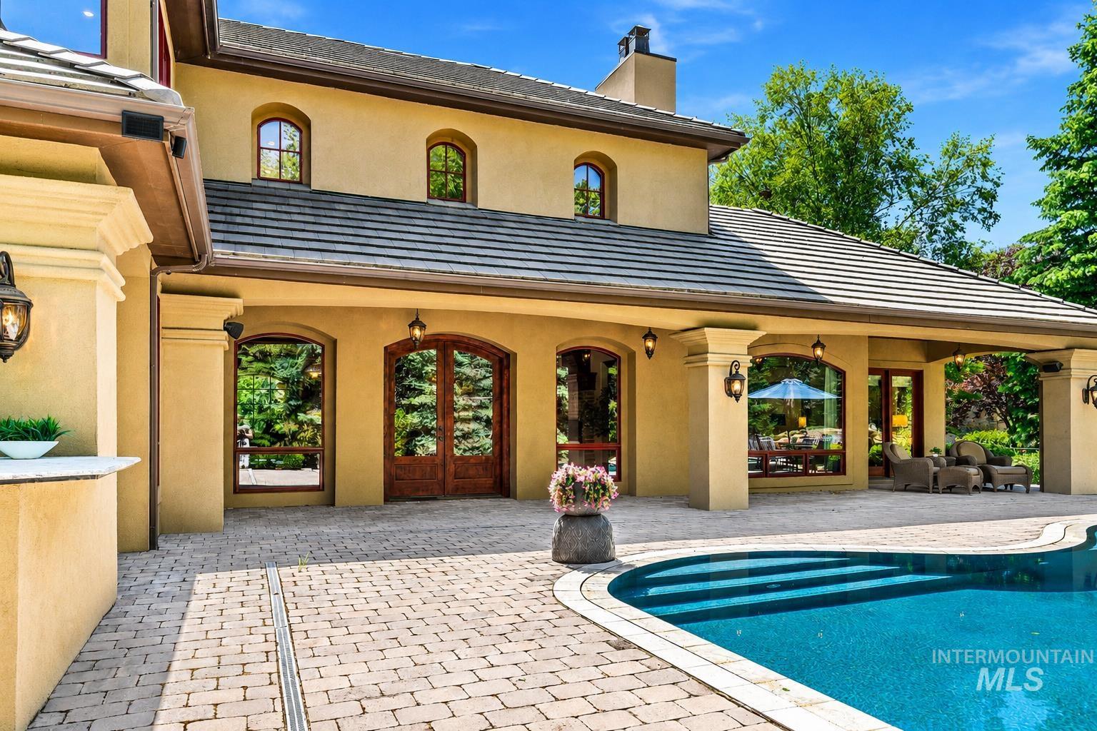 Exterior featuring stucco siding, arched windows, and a tiled roof