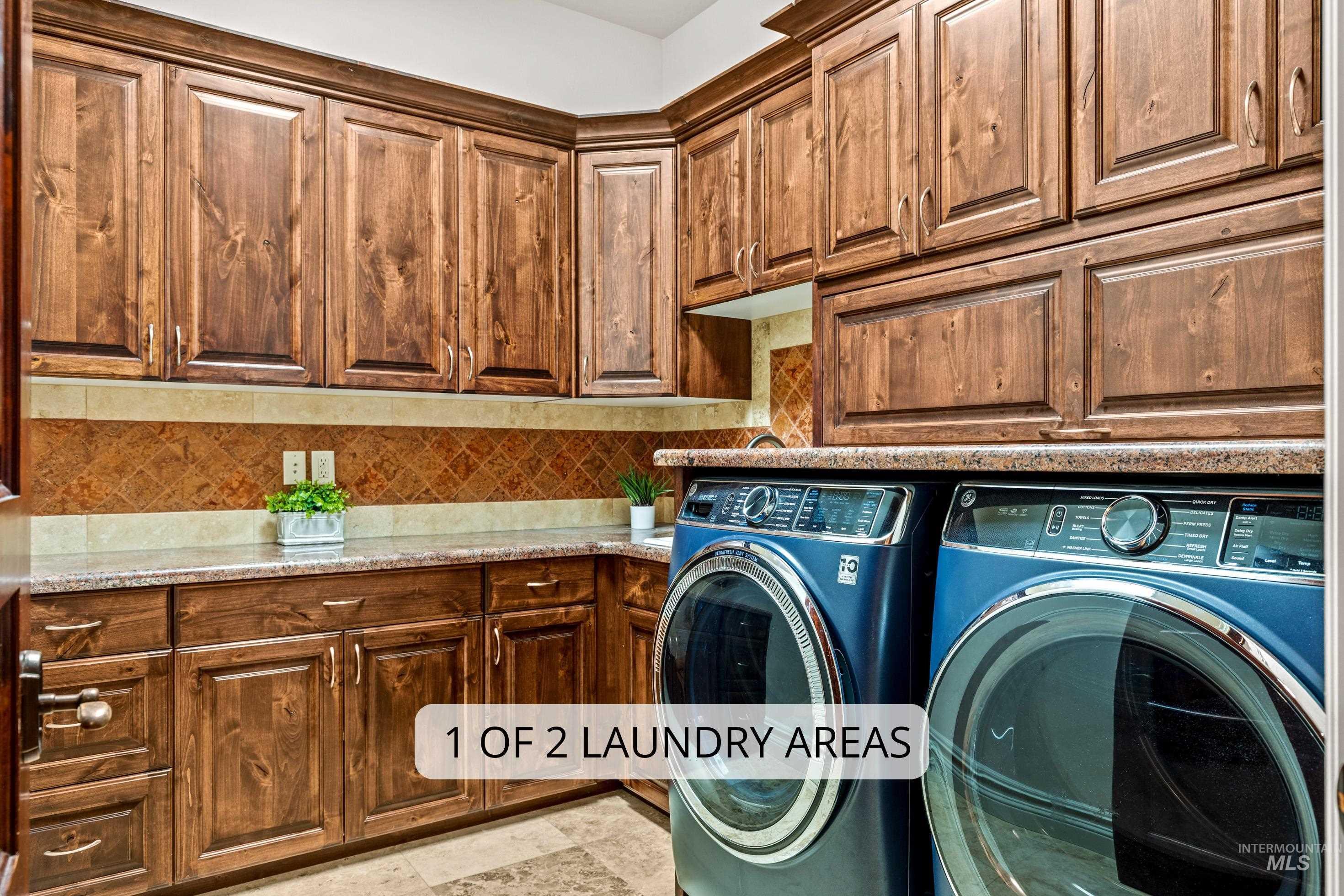 Laundry area featuring extensive wood cabinetry, stone countertops, and a patterned tile backsplash