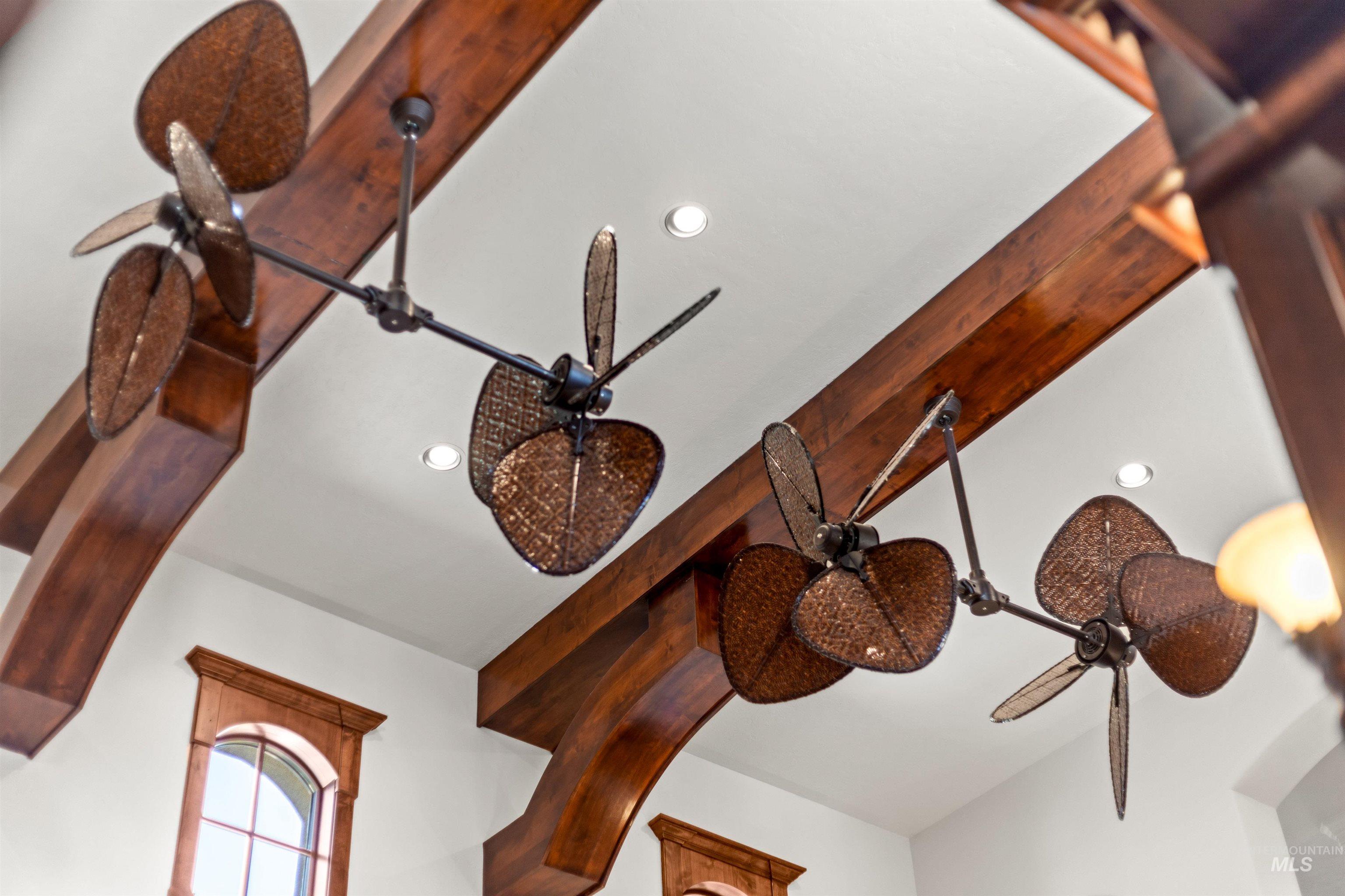 Decorative ceiling fans with woven blades, featuring exposed wood beams and recessed lighting