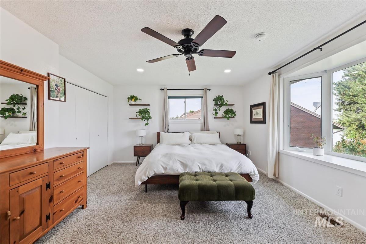 Bedroom with light carpet, a closet, a ceiling fan, a textured ceiling, and recessed lighting
