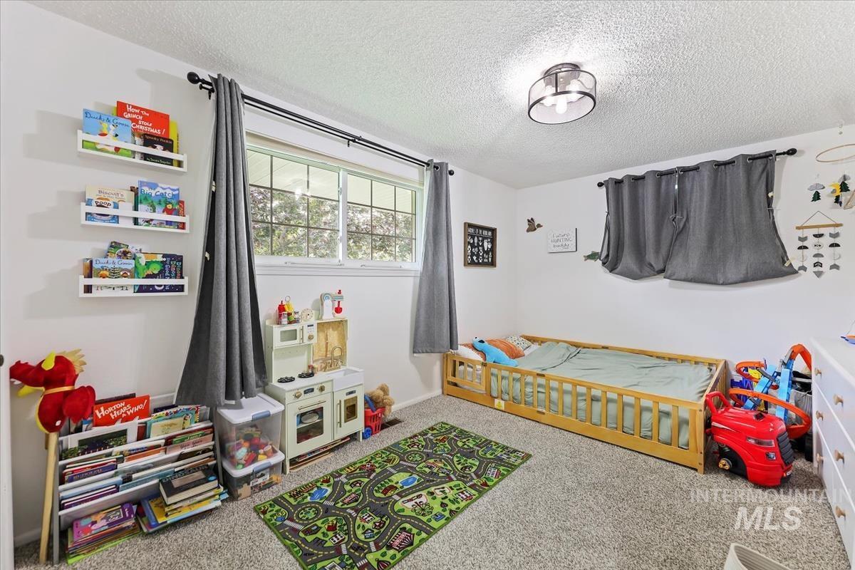 Bedroom featuring carpet flooring and a textured ceiling