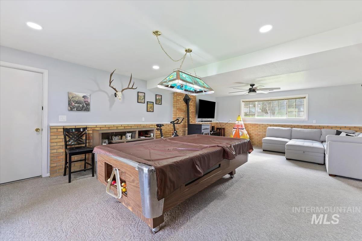 Rec room with carpet floors, billiards table, brick wall, ceiling fan, and recessed lighting