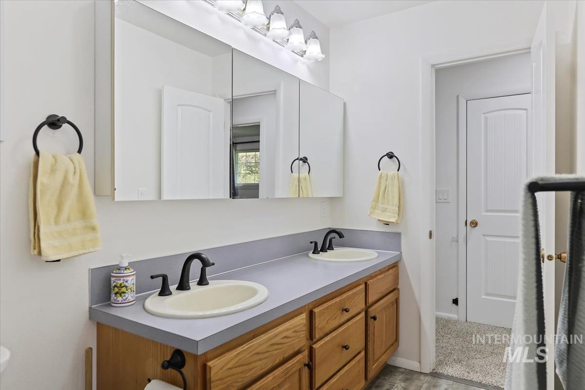 Full bathroom featuring double vanity and baseboards