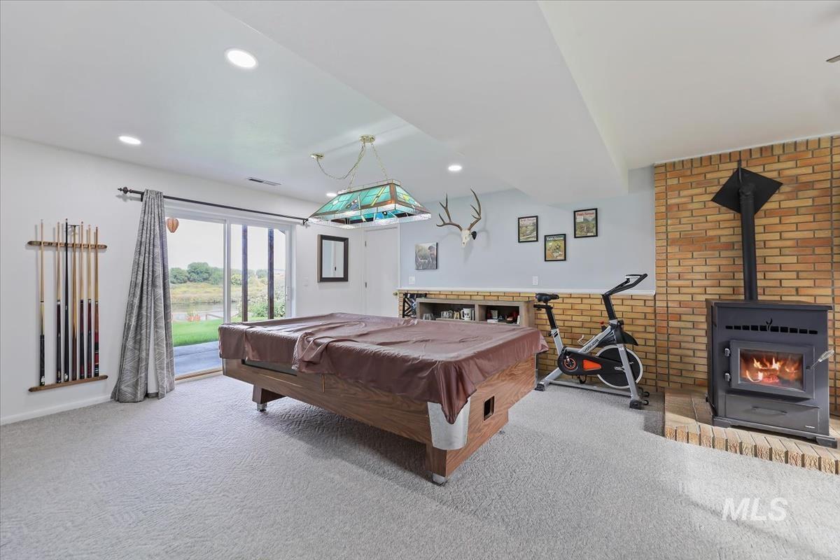 Game room with pool table, a wood stove, carpet floors, and recessed lighting