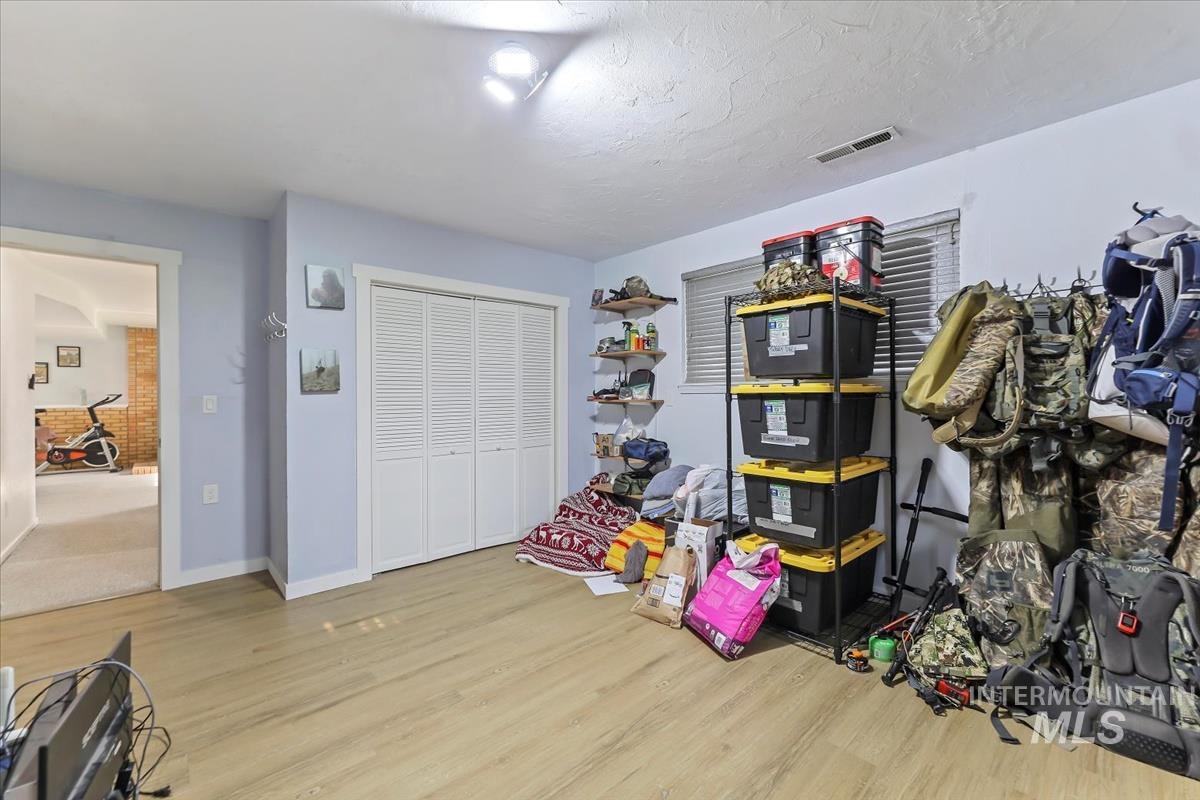 Game room with light wood-style flooring and a textured ceiling