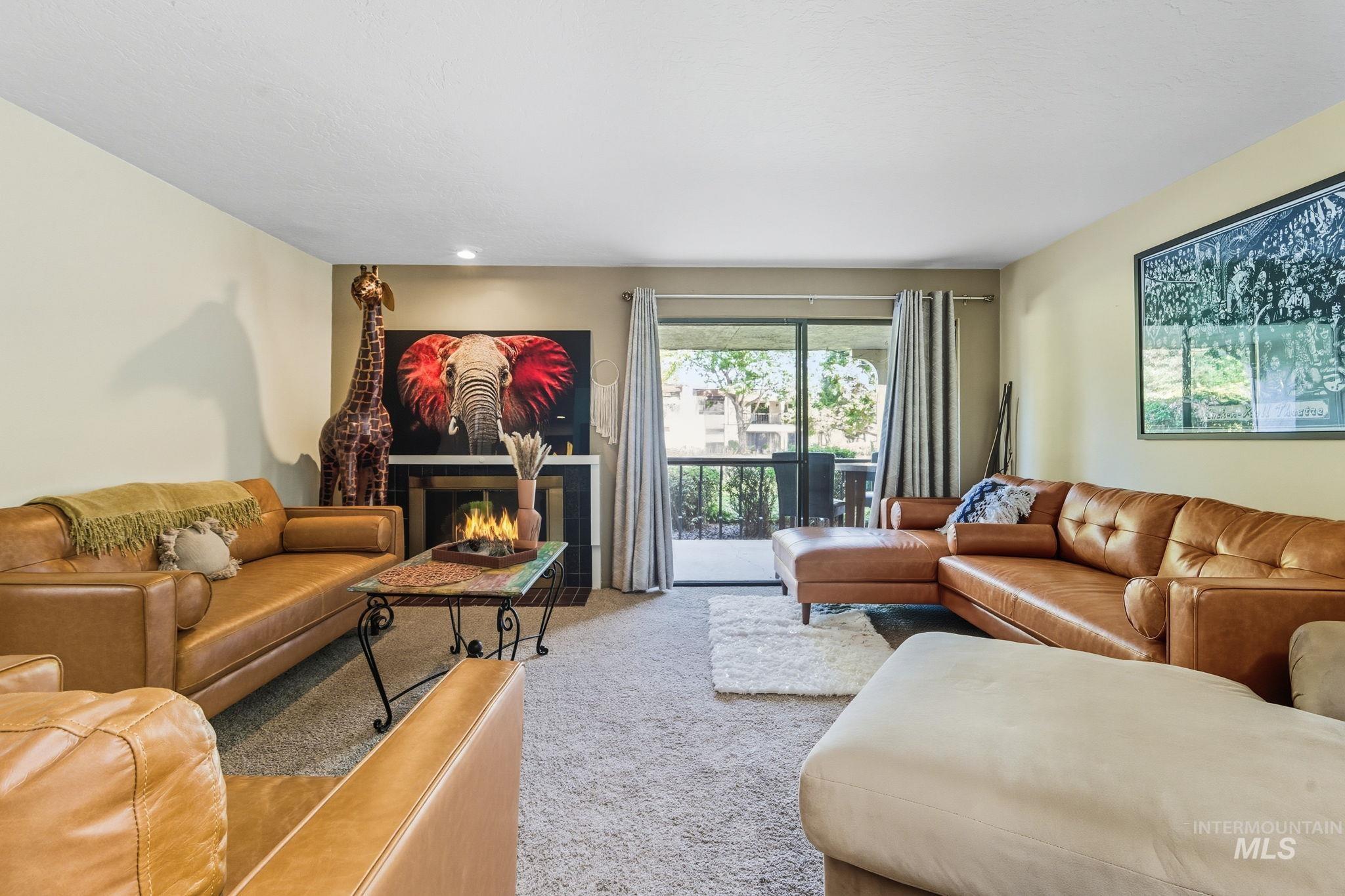 Living area with carpet floors and a tiled fireplace