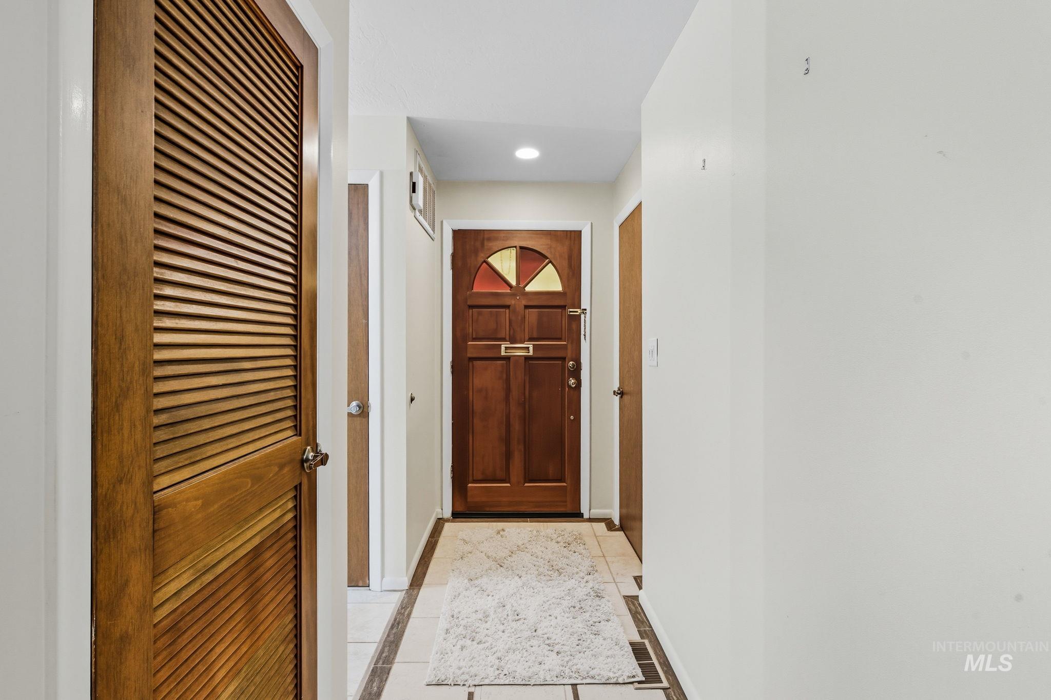 Doorway to outside with tile patterned flooring, inlaid floor details, and recessed lighting